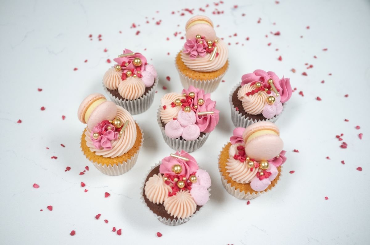 Pink cupcakes with macarons and sprinkles