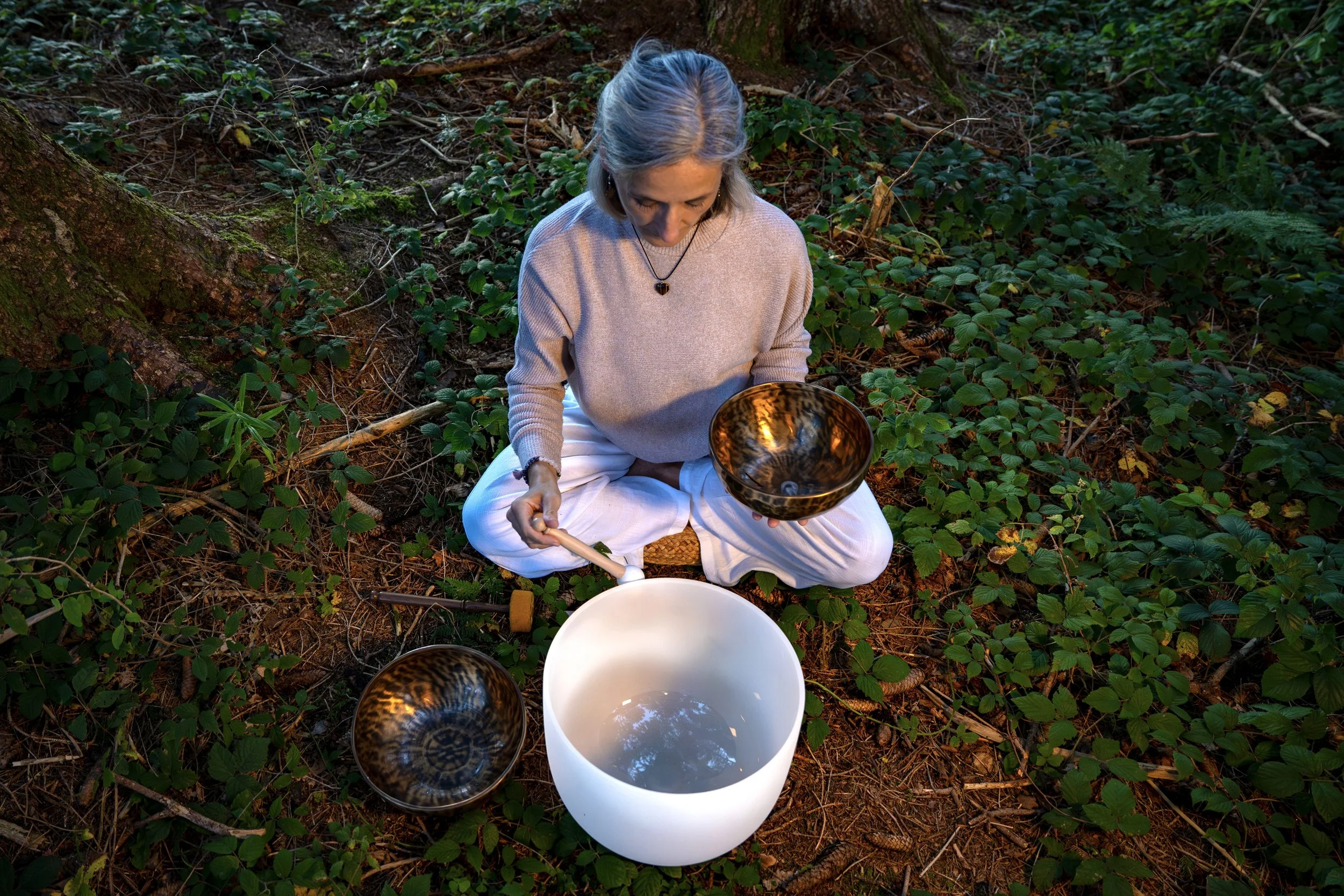 Soundhealing Yoga in Wil – Frau sitzt im Schneidersitz mit Tibetschale, Kristallschale auf dem Boden