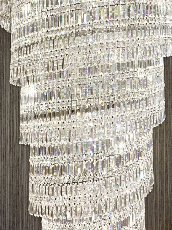 Close-up of a large, elaborate crystal chandelier with multiple rows of shimmering crystals.