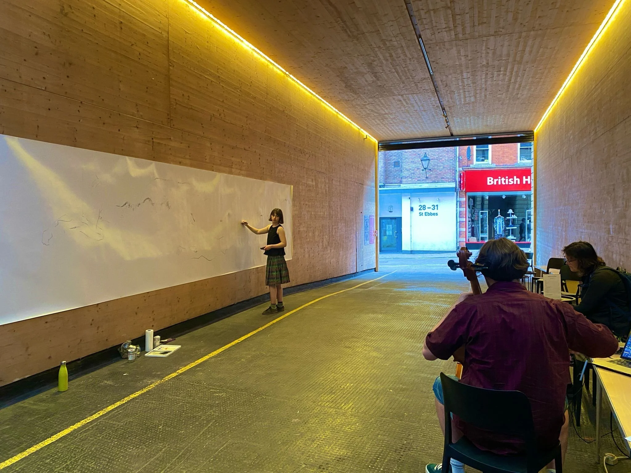 PERFORMANCE STILL FROM: TRANSLATIONS LIVE x EMPRes event at Modern Art Oxford, water-soluble graphite on paper, cello and electronics, 150 x 600 cm, 2025