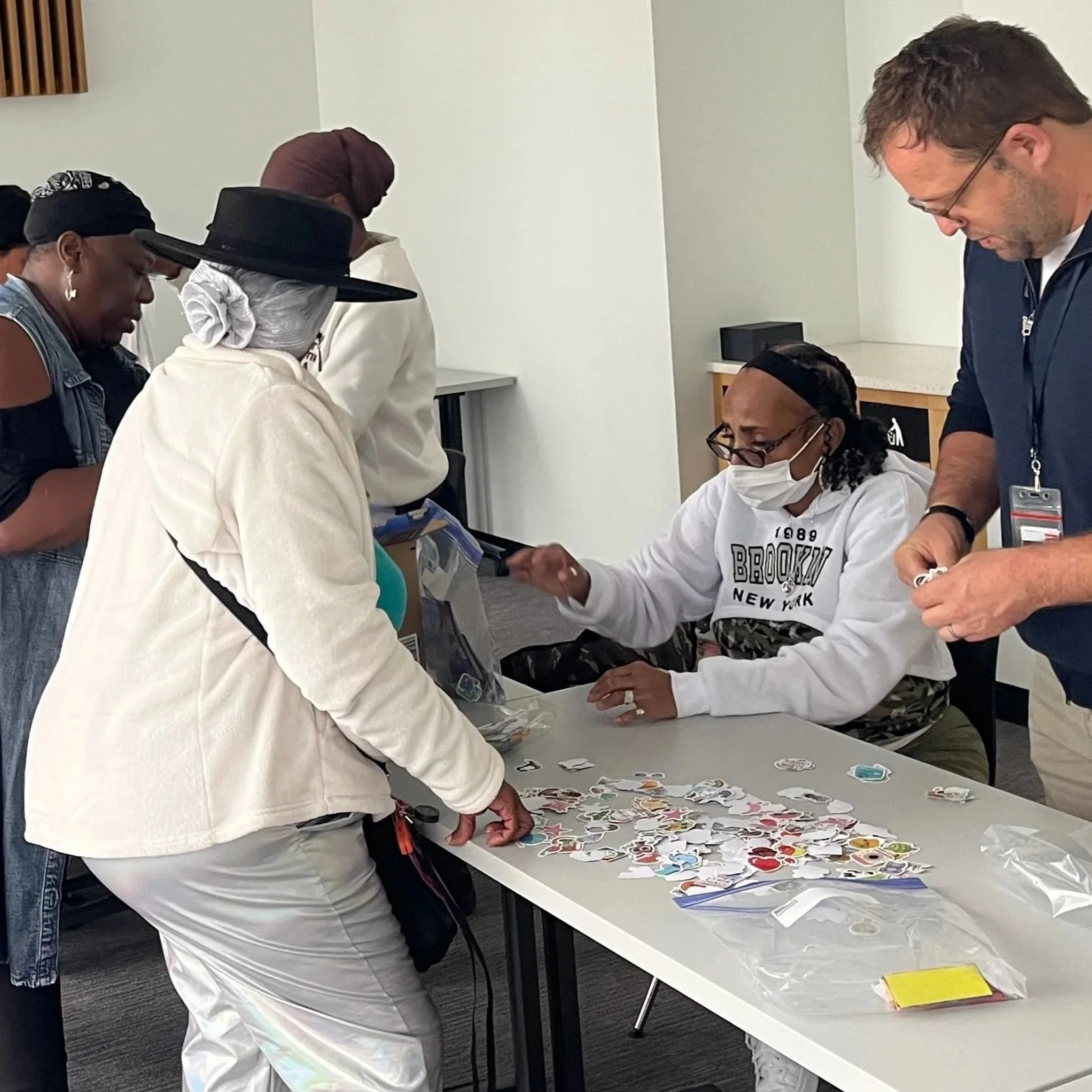 A group of community members, planners, and stakeholders gather at a public meeting to view and discuss proposed redevelopment plans for the New Communities Initiative.