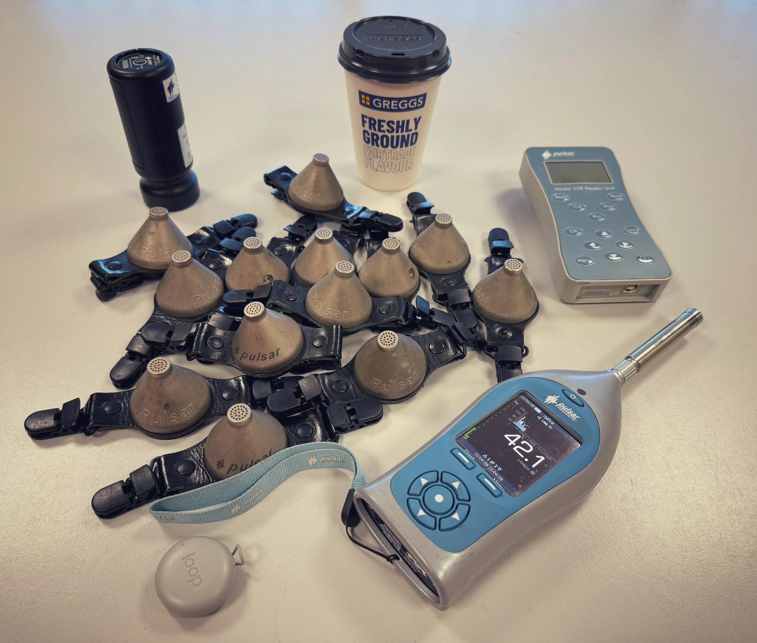 Noise meters on a table for a noise assessment, with the critical Greggs coffee cup.