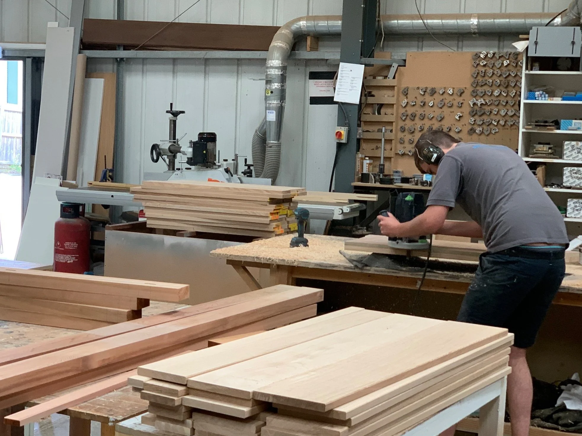Shows a men working on a bench, wearing ear muffs, in a joinery workshop noise assessment