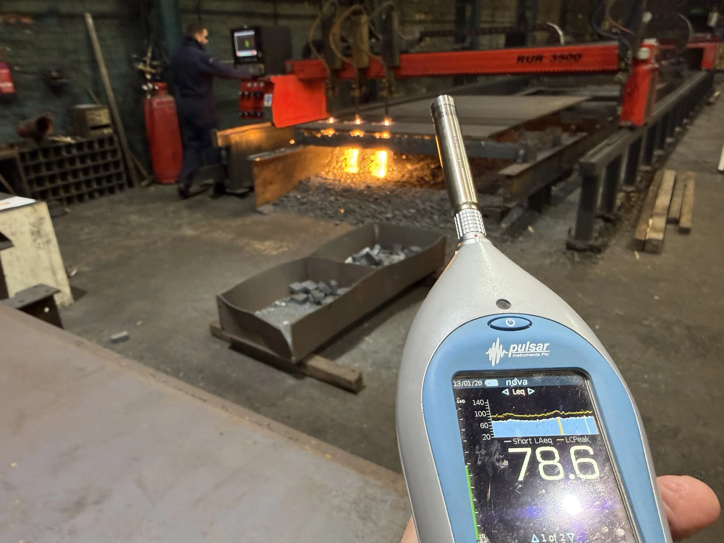 Noise meter being held in a noise assessment near a plasma cutter