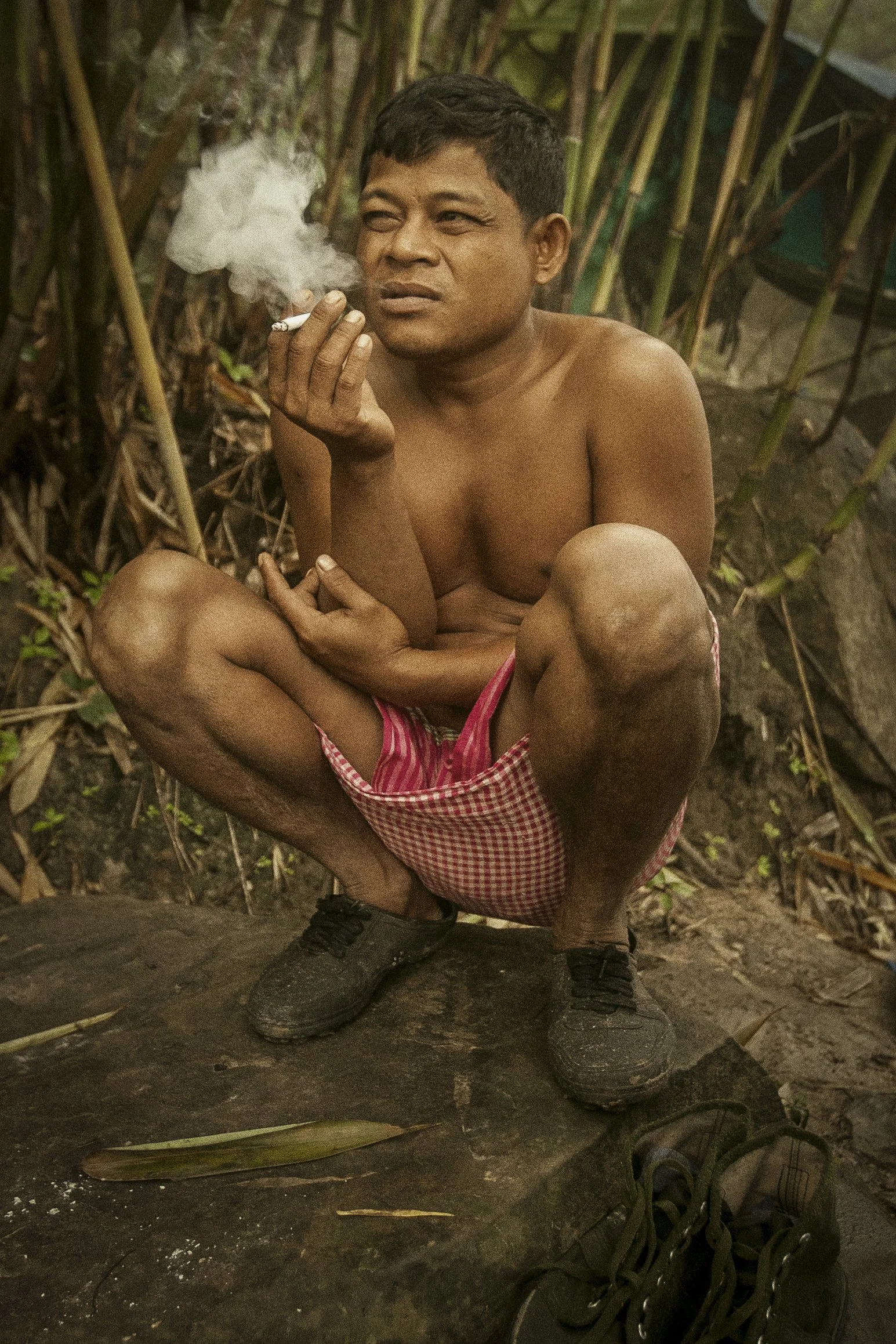 A morning cigarette helps begin the day deep within the jungle.