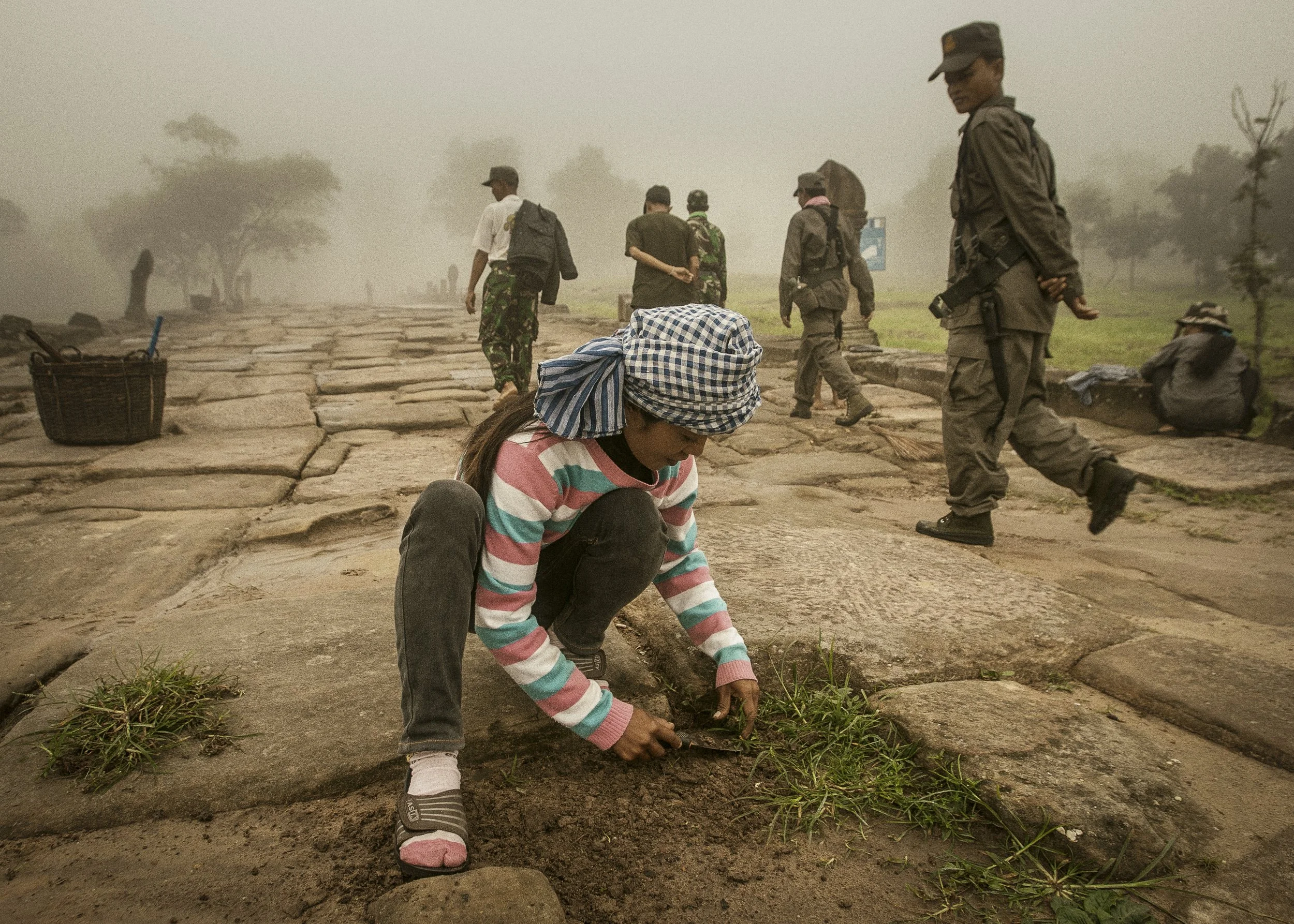 Local villagers tending to and maintaining one of the ancient stone pathways leading to the temple entrance.