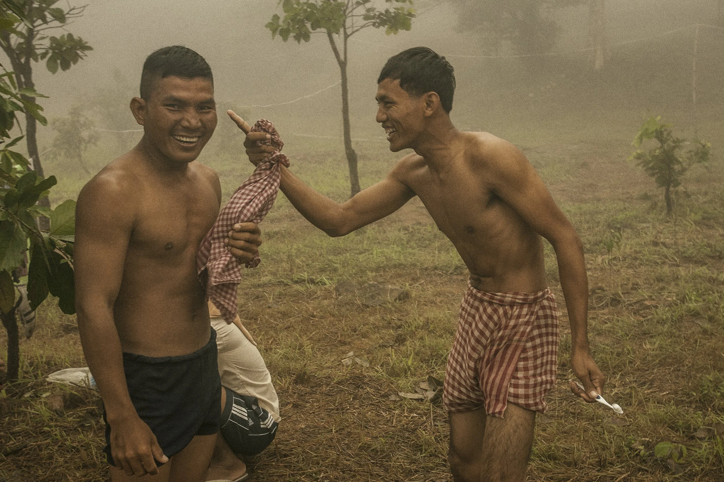 Cambodian troops with some levity among the mountain mist for their morning wash and oral hygiene routine.