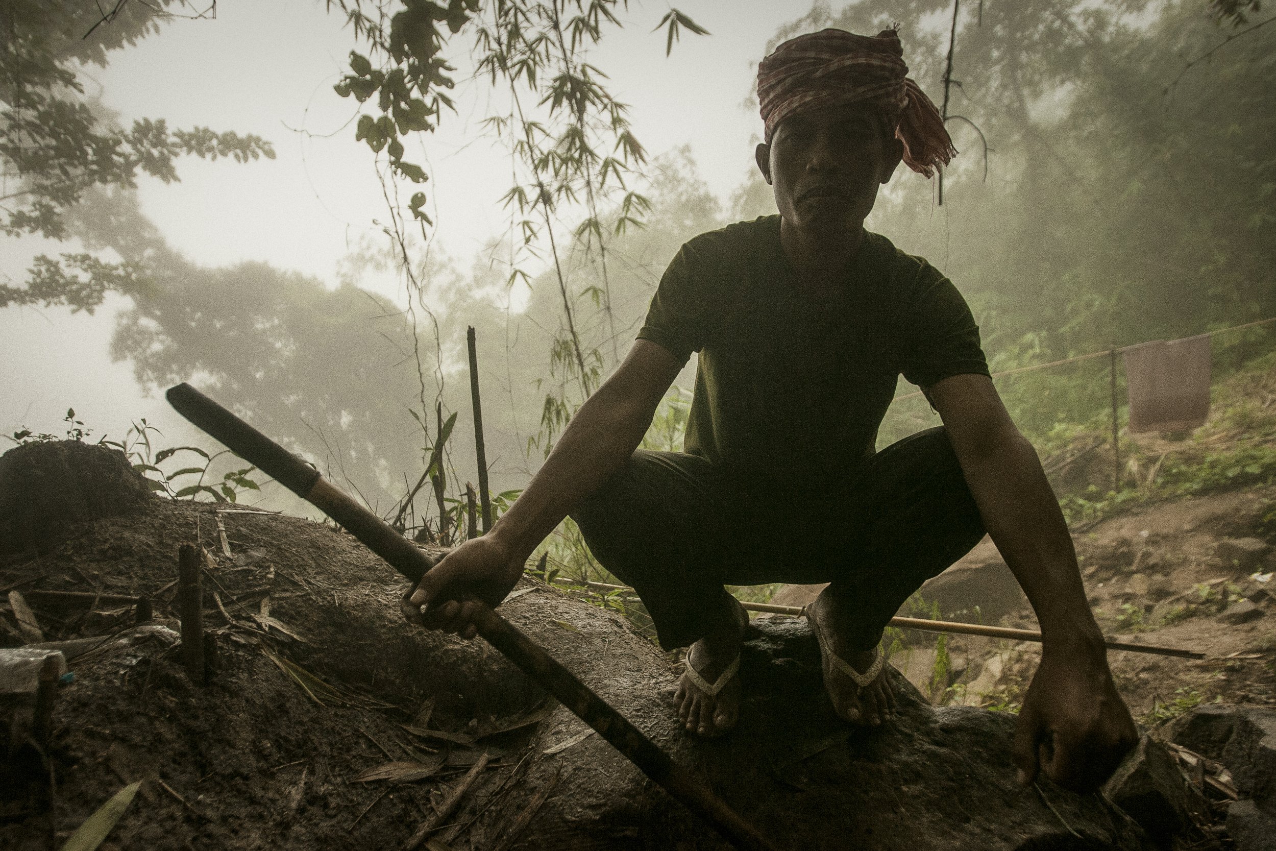 Chea Vannak, an eighteen year veteran with the RCAF pauses in the dense morning mist, inspecting the jungle area surrounding his mountain camp.