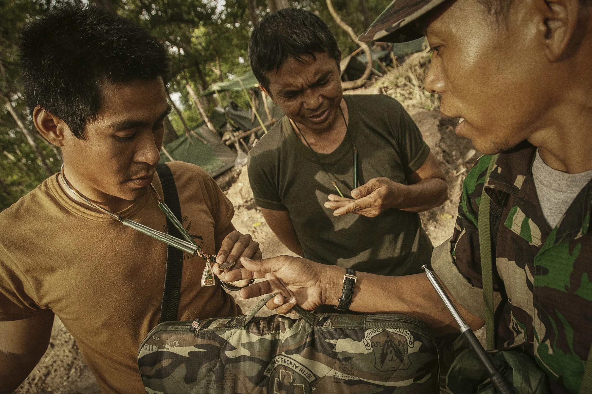 Thai Lieutenant Fah Ari shows his protective amulet and sacred talisman to RCAF troops.