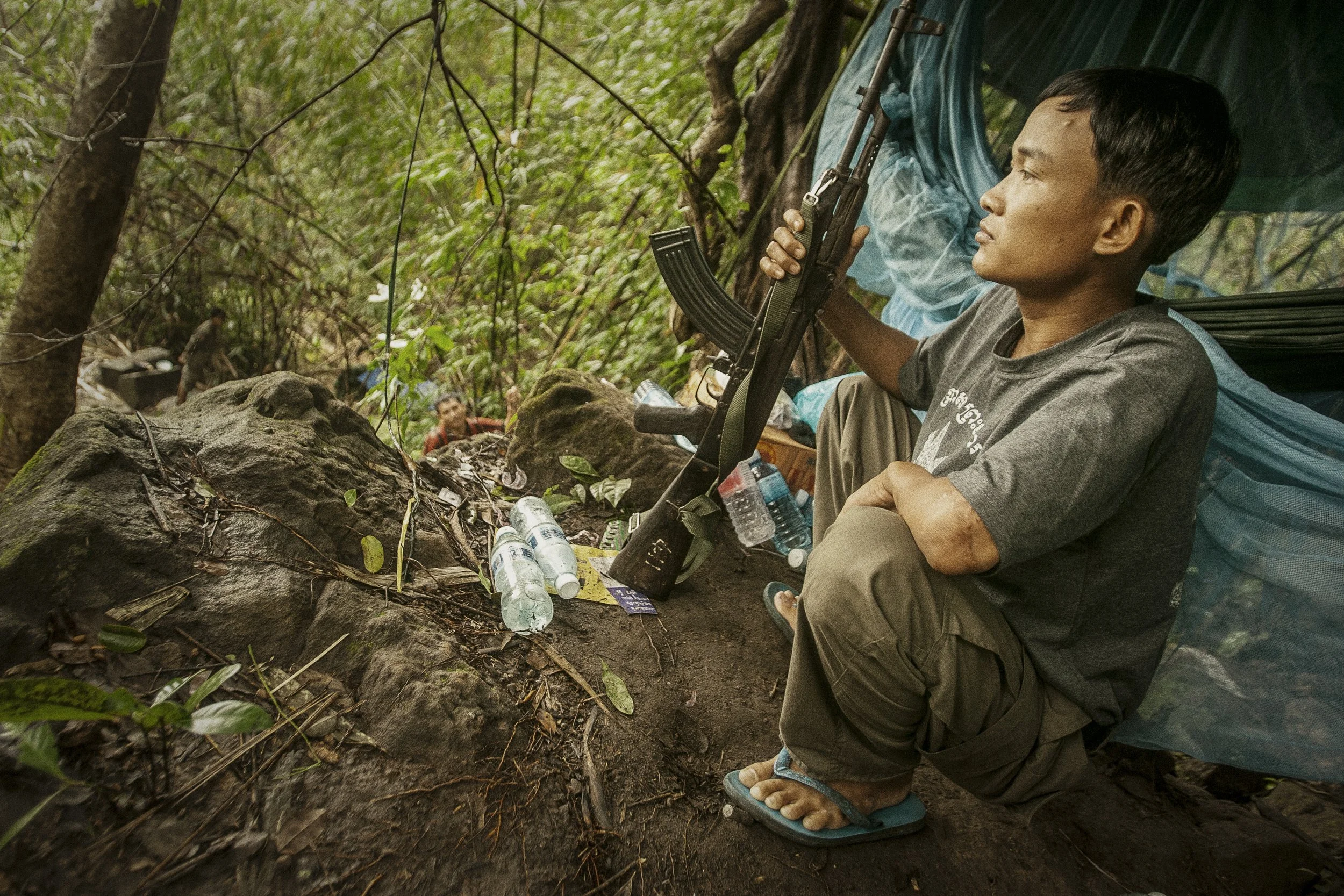 An RCAF soldier with his Soviet era AK-47 surveys the surrounding jungle from his small and isolated outpost on the mountainside.