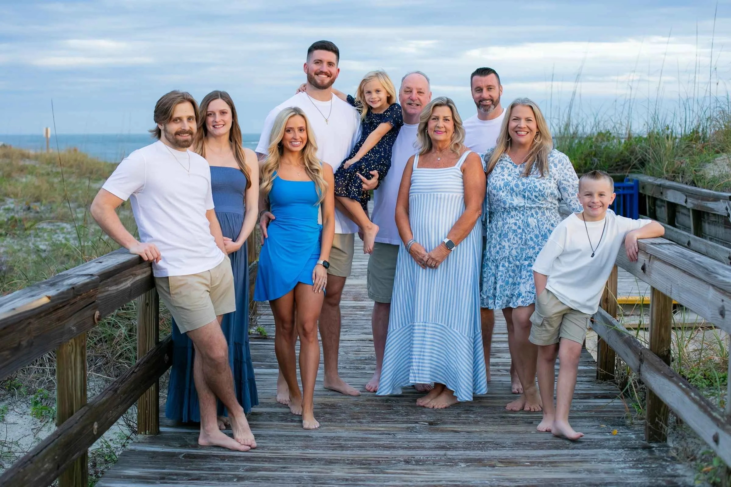 Family group photo on a wooden boardwalk at the beach during sunset for a family portrait session with Cannonfire Photography.