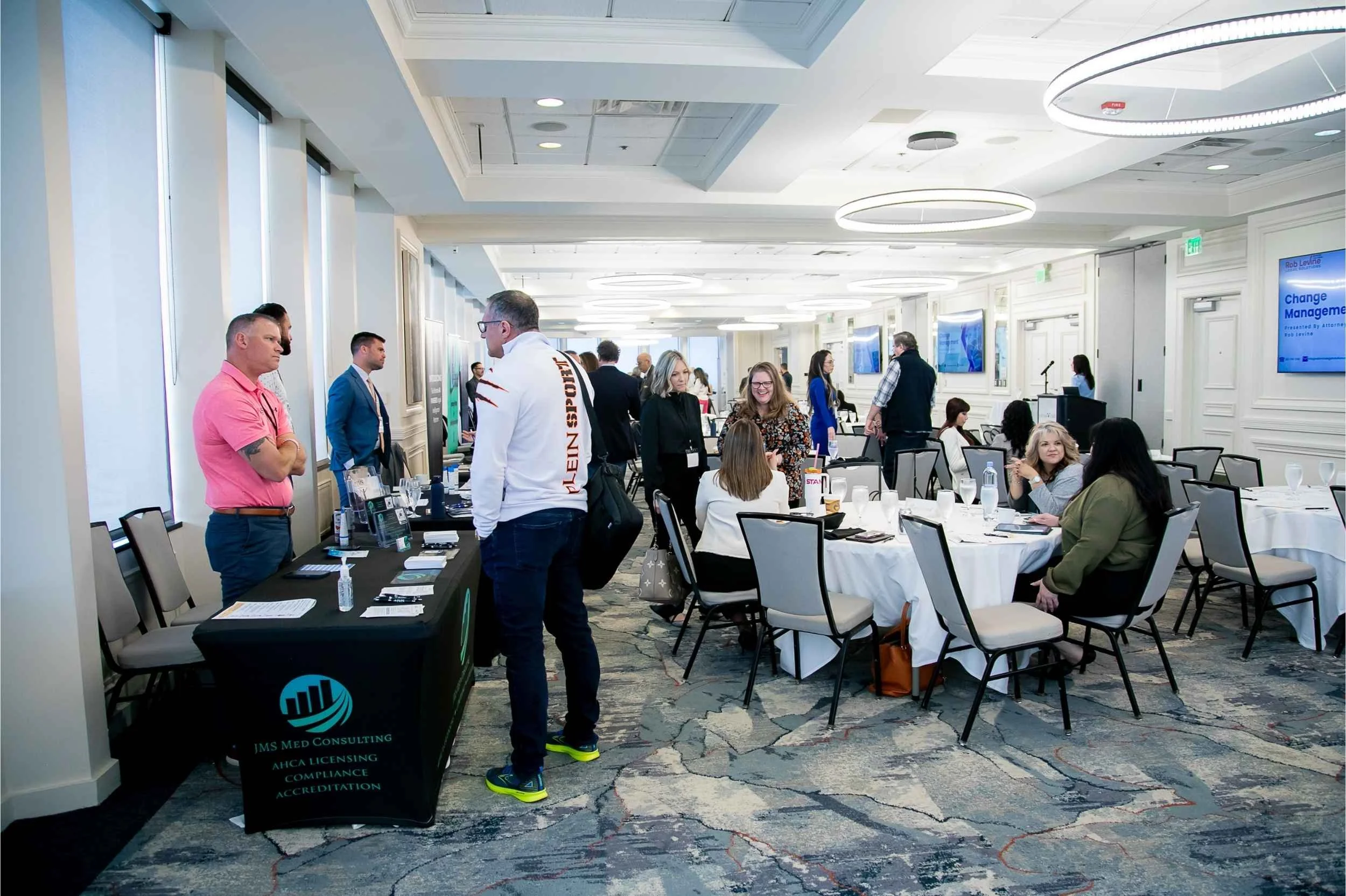 Attendees gathered together at informational tables for a corporate event at the Citrus Club in Orlando