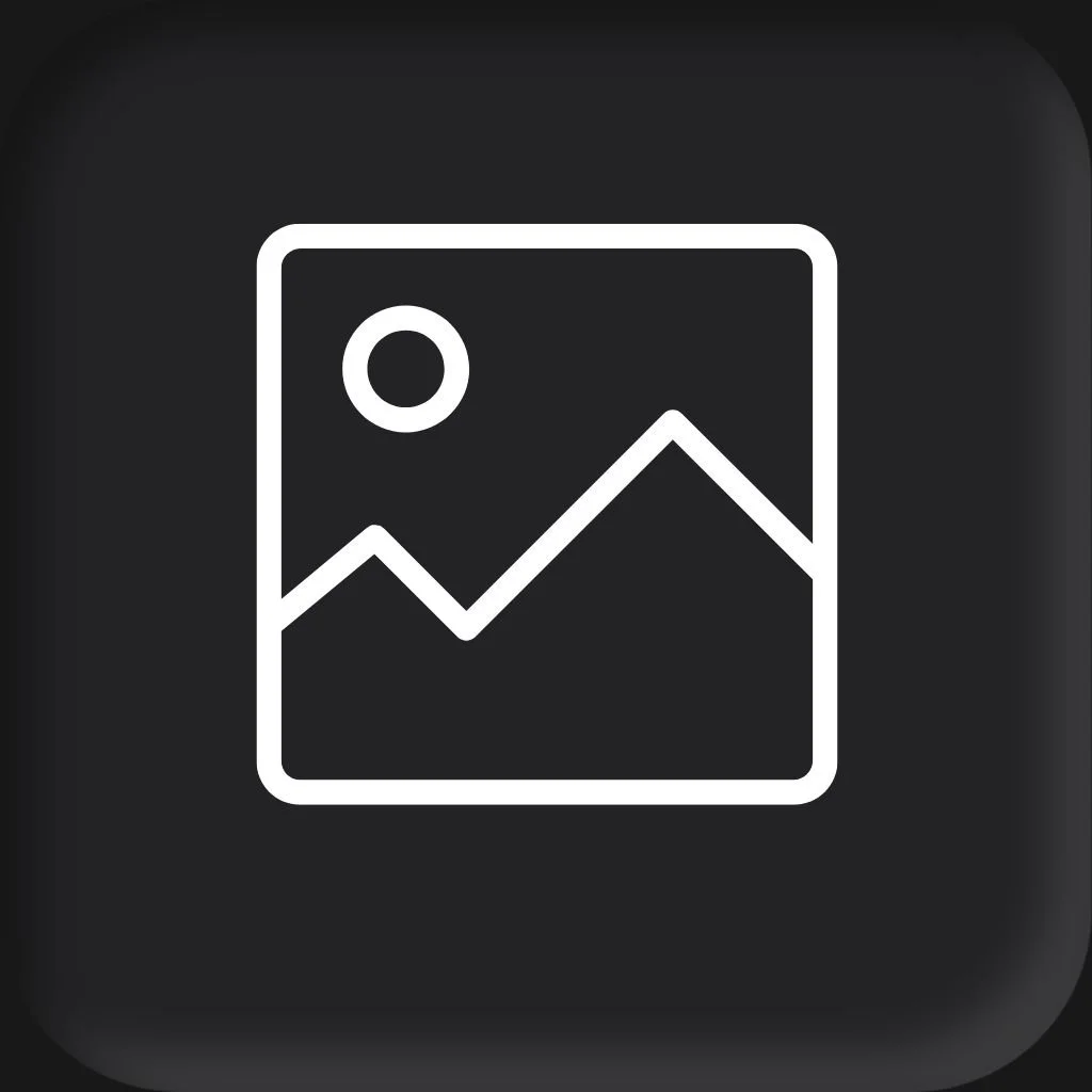 A woman with brown hair, glasses, and a floral sleeveless dress smiling in front of a brick wall for a headshot session with Cannonfire Photography..