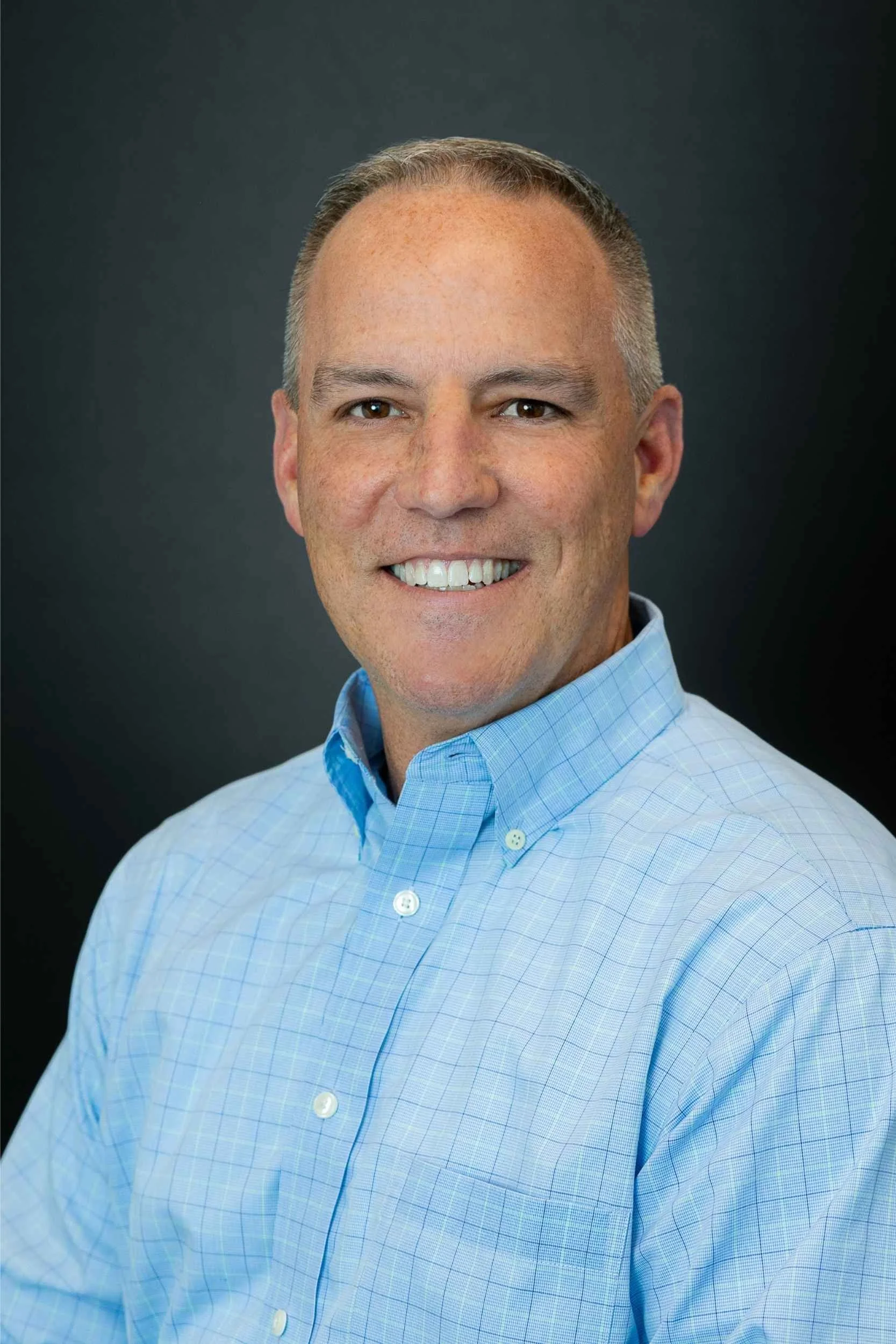 Professional headshot of an insurance agent with natural retouching, indoor studio setting in Winter Garden.