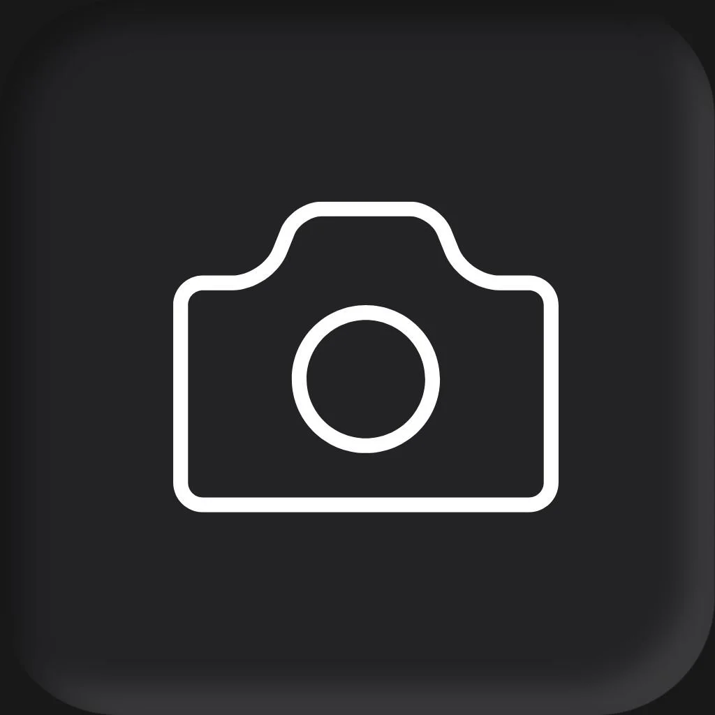 A professional headshot of a man wearing a light gray blazer and a navy blue checkered shirt, smiling against a dark gray background for a session with Cannonfire Photography in Orlando..