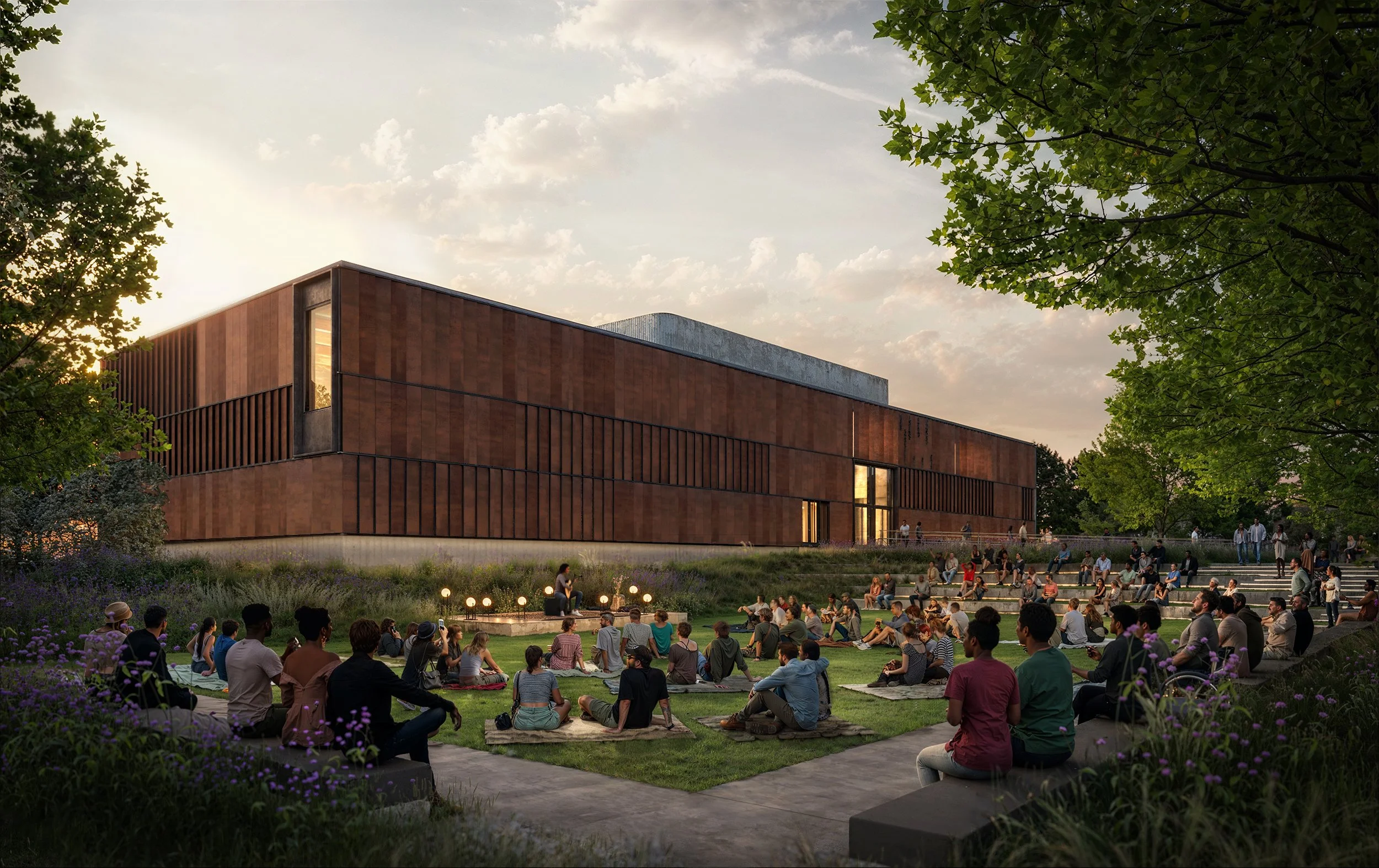 People sitting and gathering on steps and on the grass in front of a modern, large building with wooden exterior, during sunset, with trees and a partly cloudy sky in the background.
