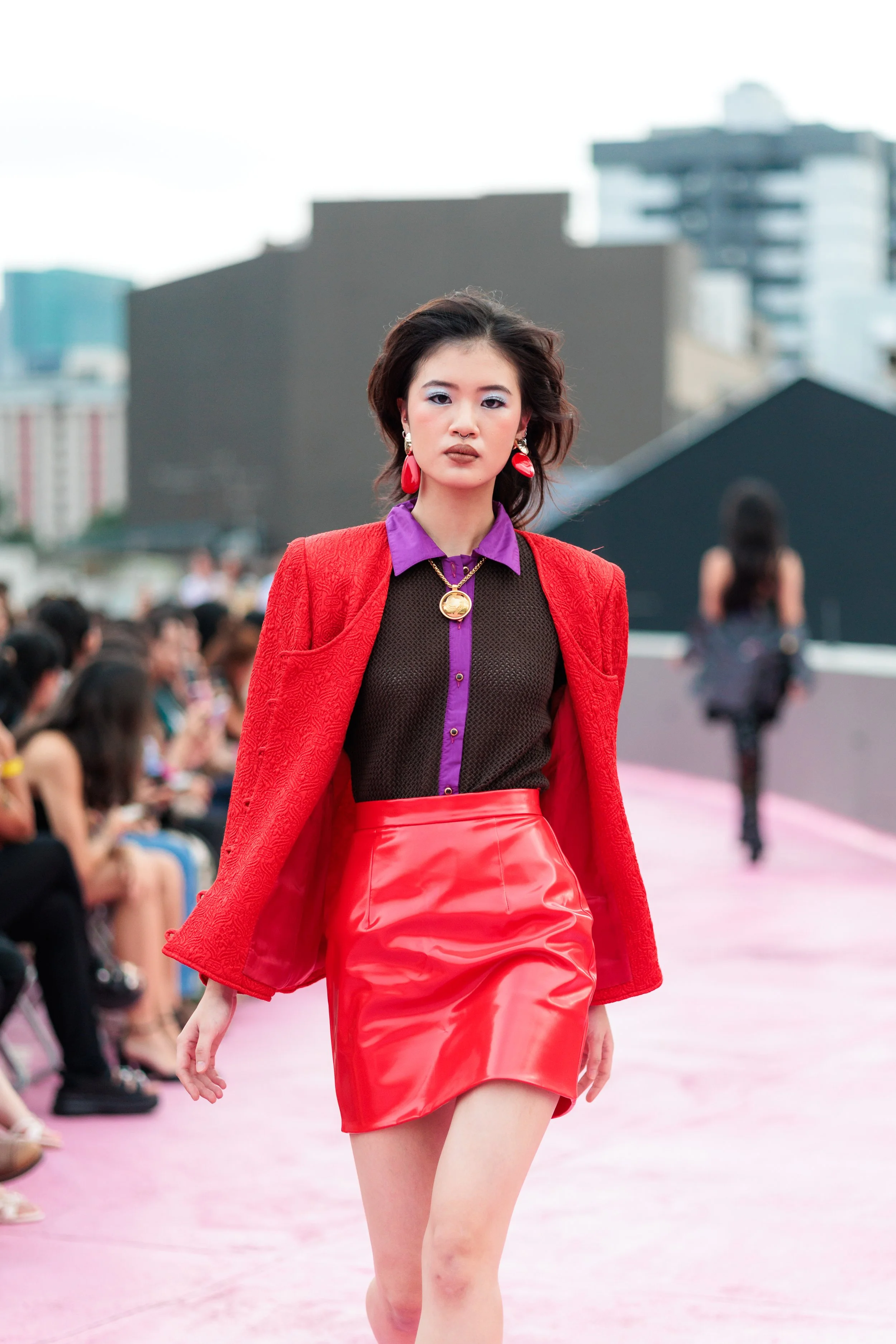 A female model walking on a pink runway during a fashion show. Event Photography. Fashion Photography. Event Videography. Walkway Photography & Videography. Circular Fashion