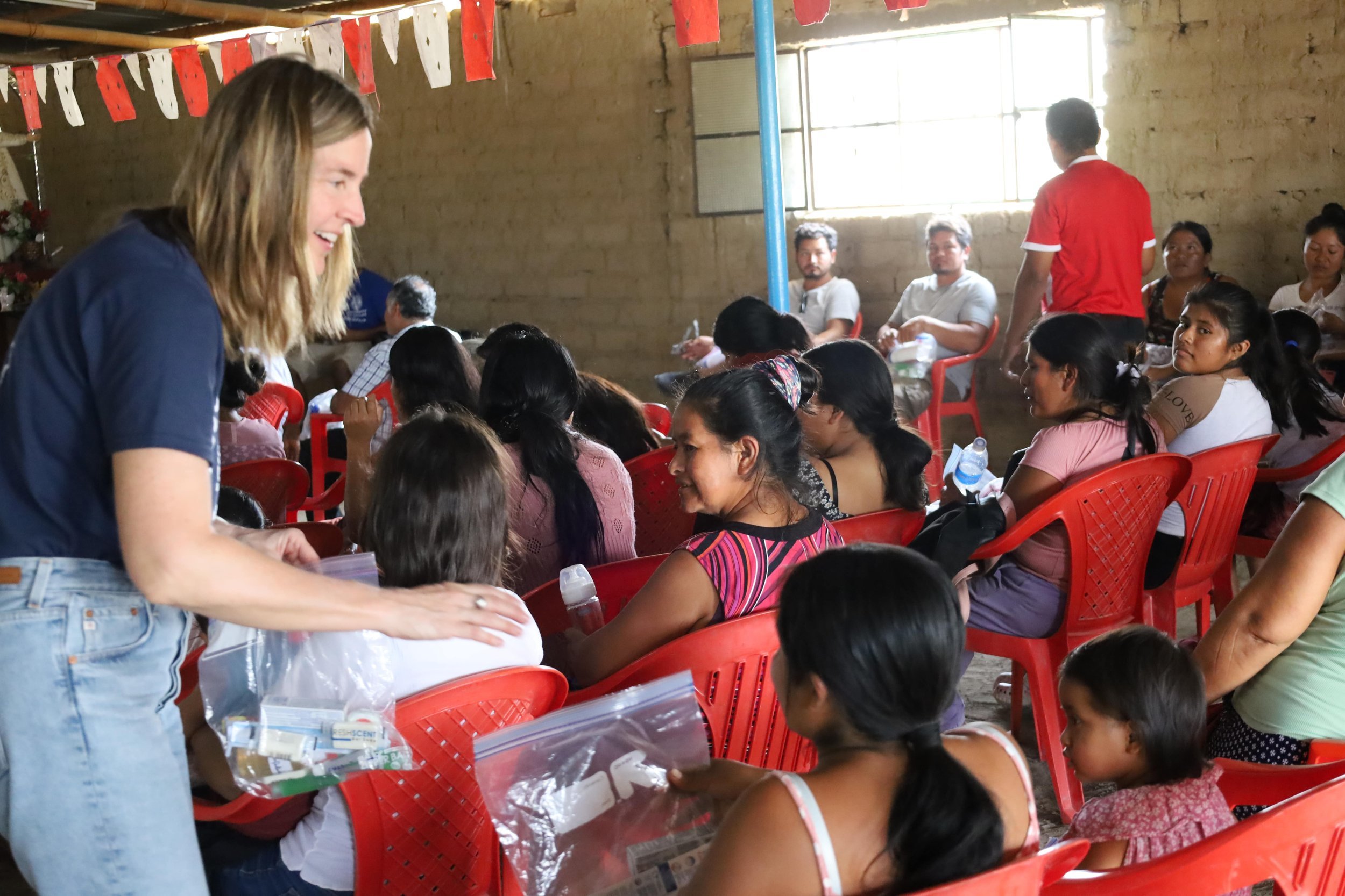 Smiling Missionary hands out Care Packages to underserved families in Piura, Peru.