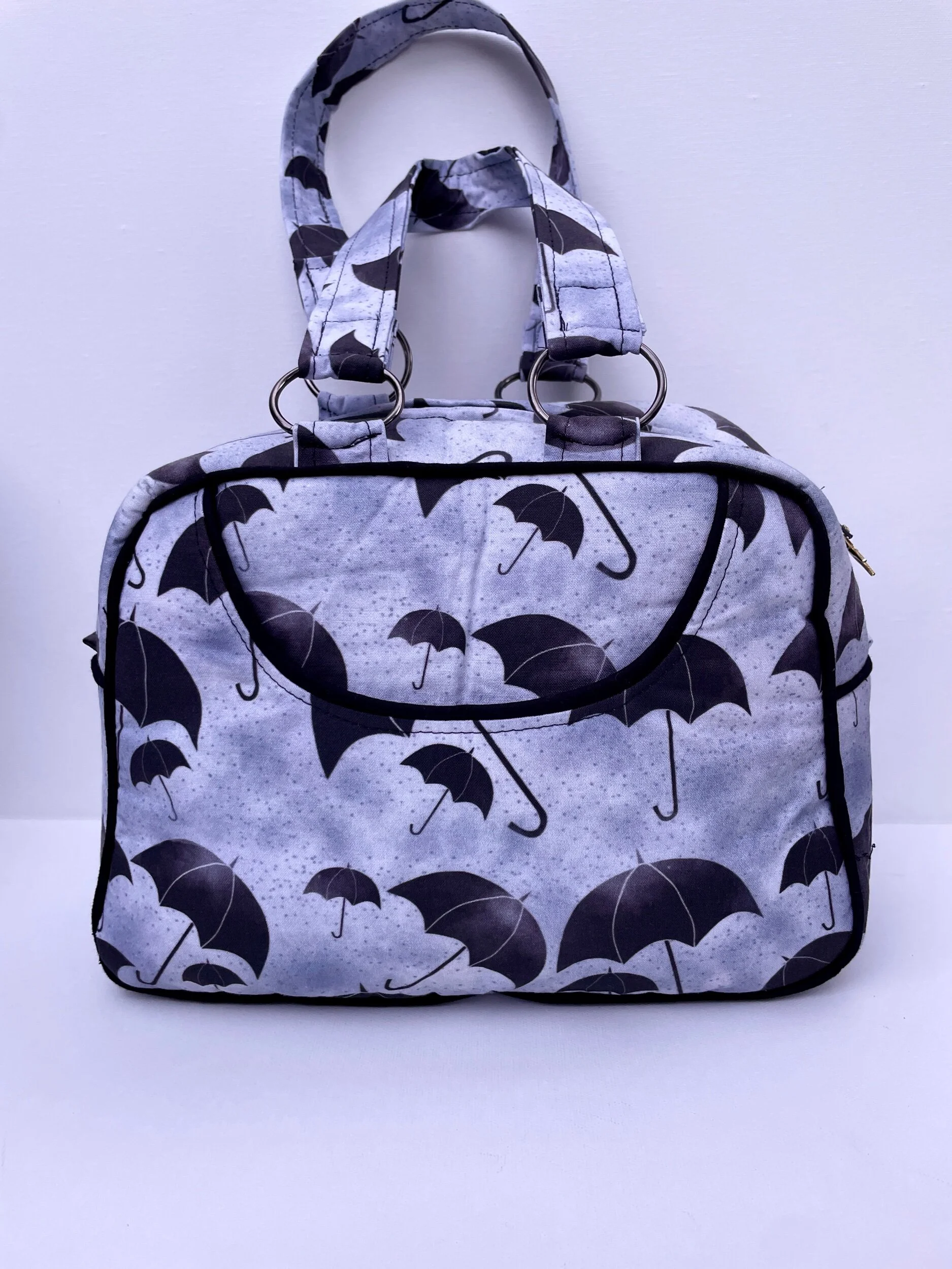 Gray bag with black umbrella pattern on a white background.