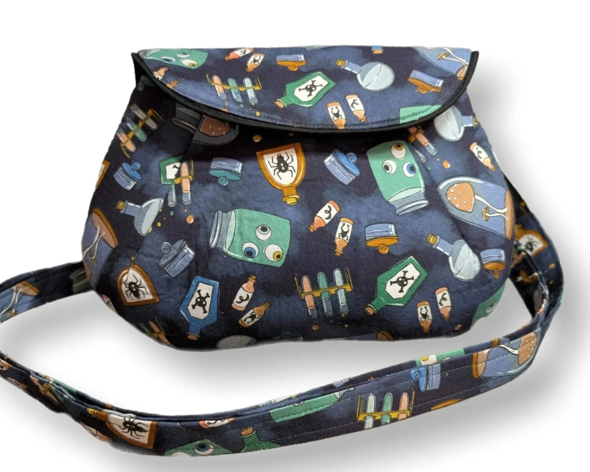 A navy blue fabric bag with a pattern of cartoon medicine bottles, ointment tubes, and pill jars with faces and symbols.