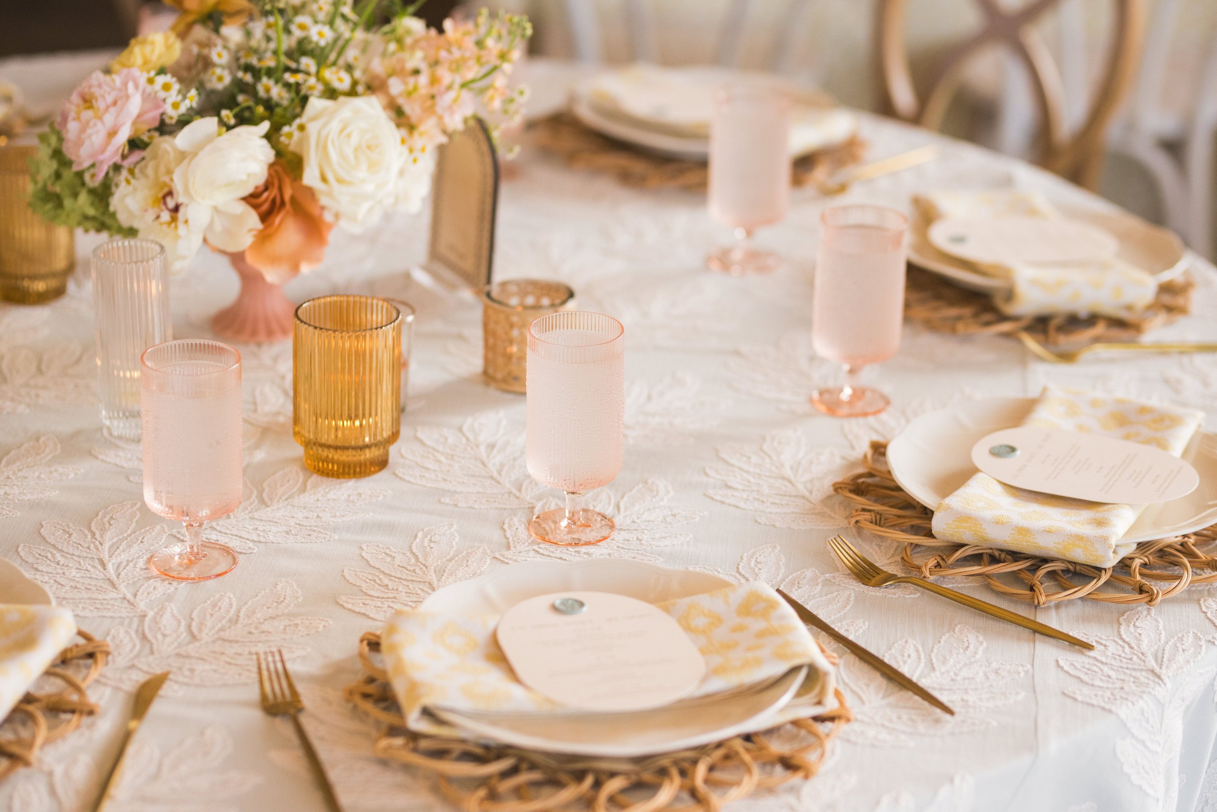  A table setting with pink and gold glass rentals and tableware at event. 