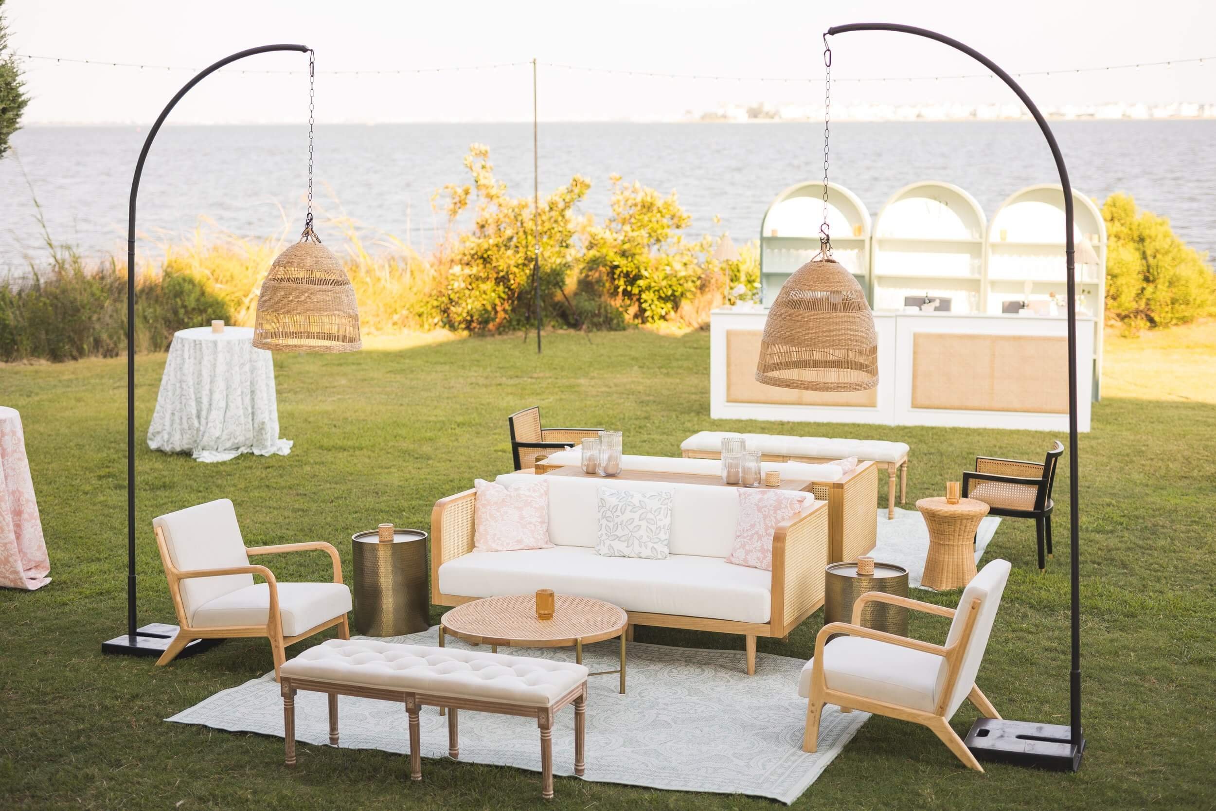  An outdoor living room lounge collection with white furniture and wicker chairs on the OBX sound. 
