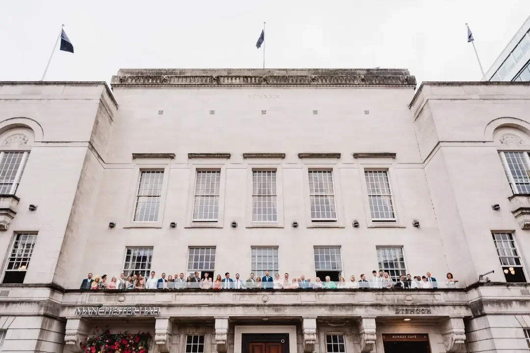 Exterior of Manchester hall with guests on a balcony