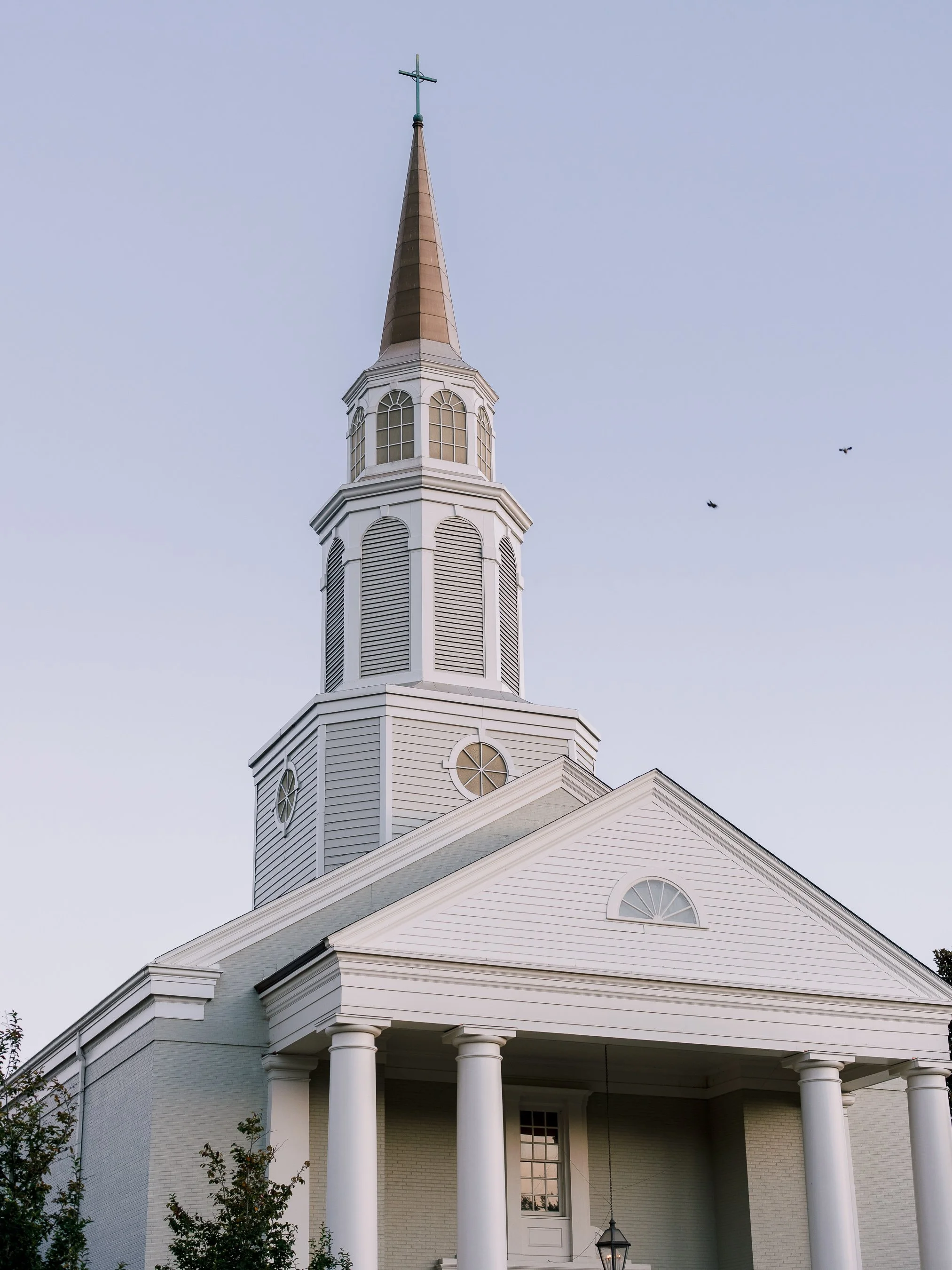 White church steeple against a soft blue sky at St. George’s Episcopal Church in Nashville, Tennessee, photographed by Brandon Chesbro