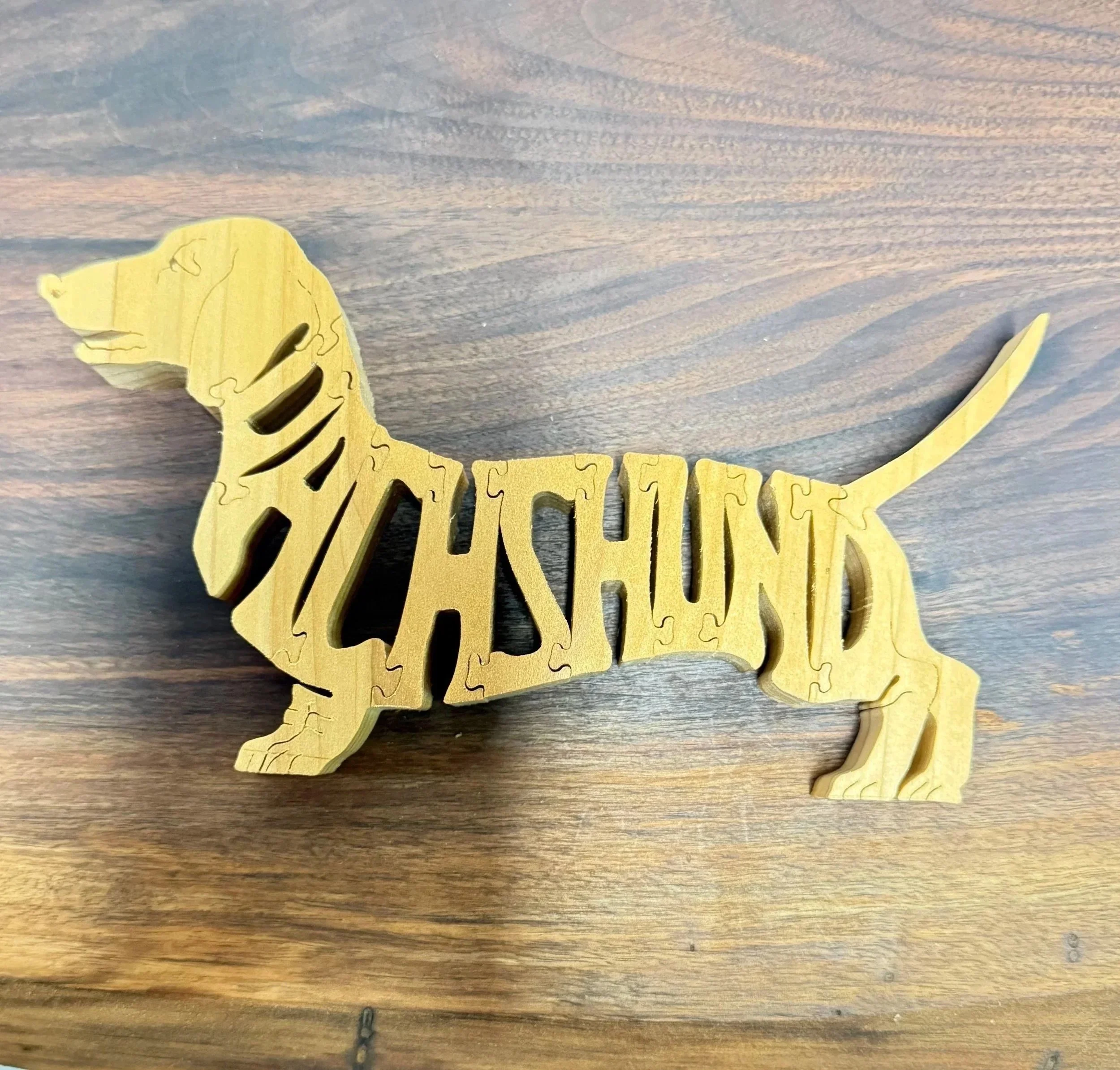 Dachshund scroll saw puzzle assembled on a walnut surface.