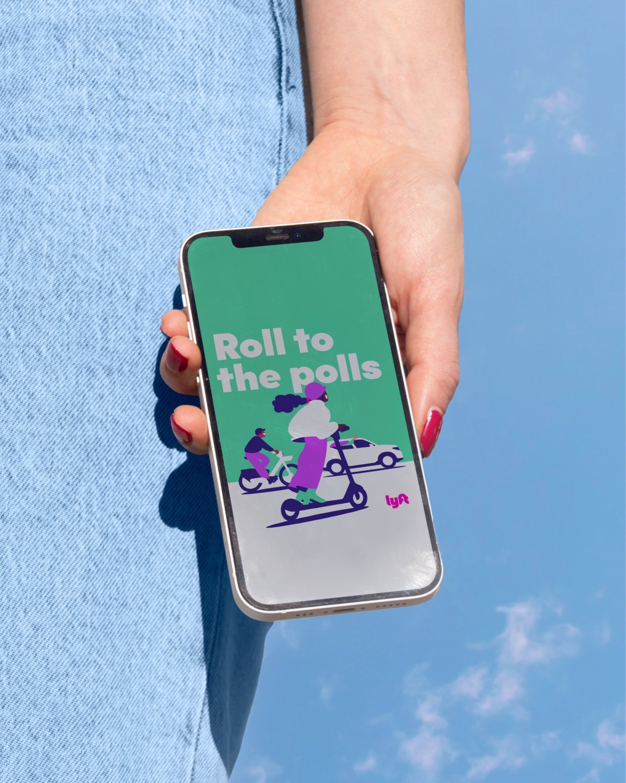 Person holding a smartphone with a screen displaying the text 'Roll to the polls' and a graphic of people riding scooters and bicycles against a blue sky background.