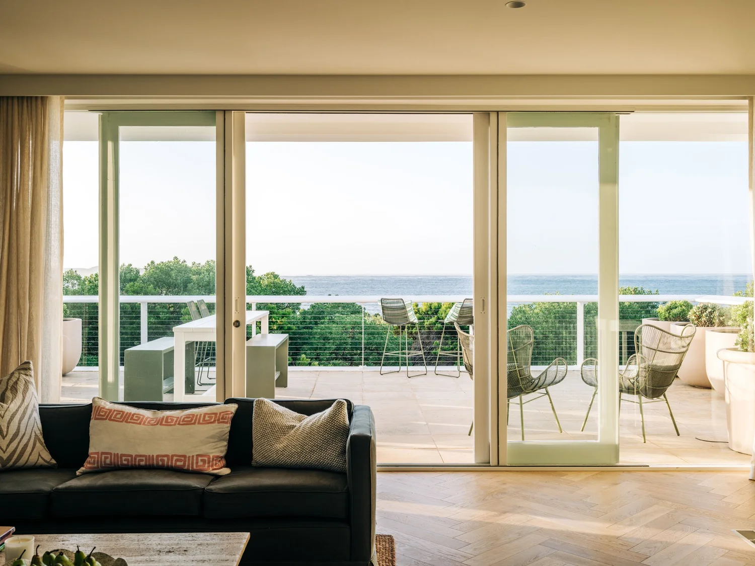 Living room opening onto the balcony at Sagres Queenscliff, with outdoor seating and views across Port Phillip Bay