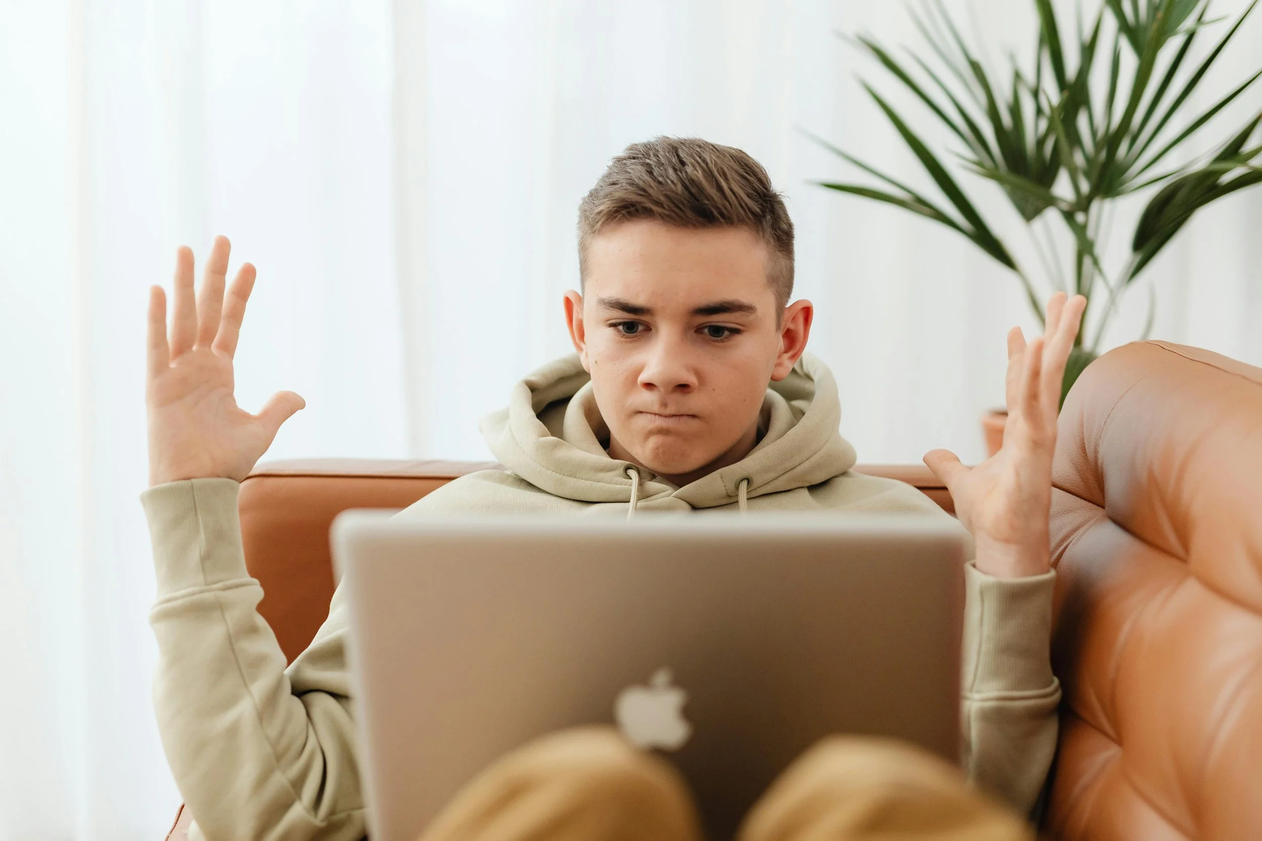Teen boy experiencing frustration at a laptop, representing teen mental health challenges
