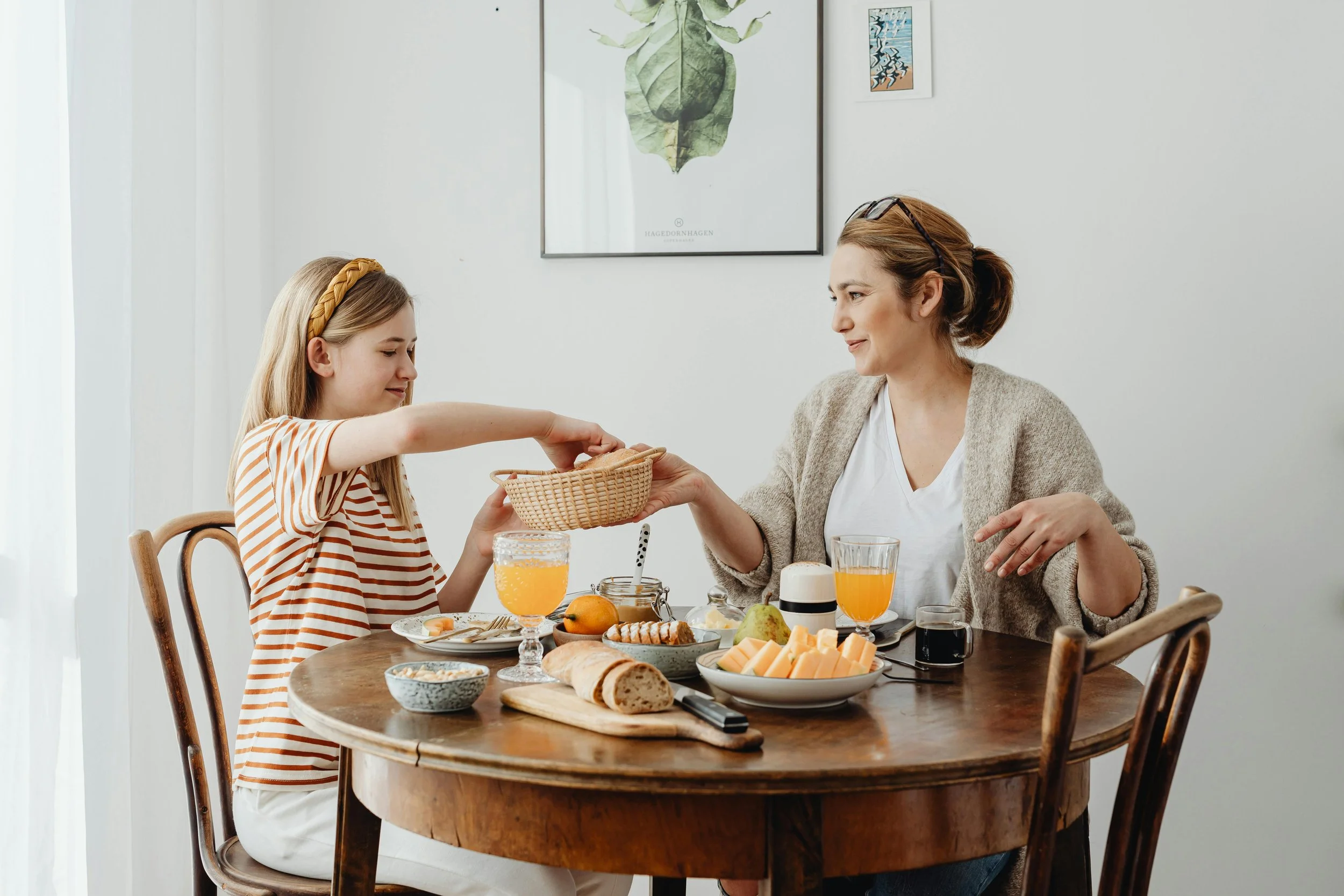 Mom and teen enjoying a relaxed meal together, reflecting healthy family relationships and emotional wellbeing.
