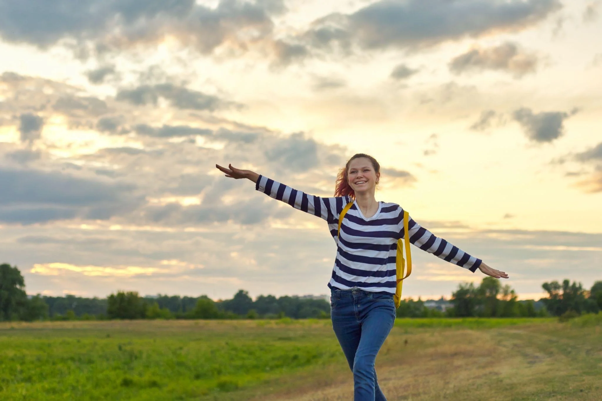 Confident teenager embracing mental health wellness after learning healthy coping skills through therapy.