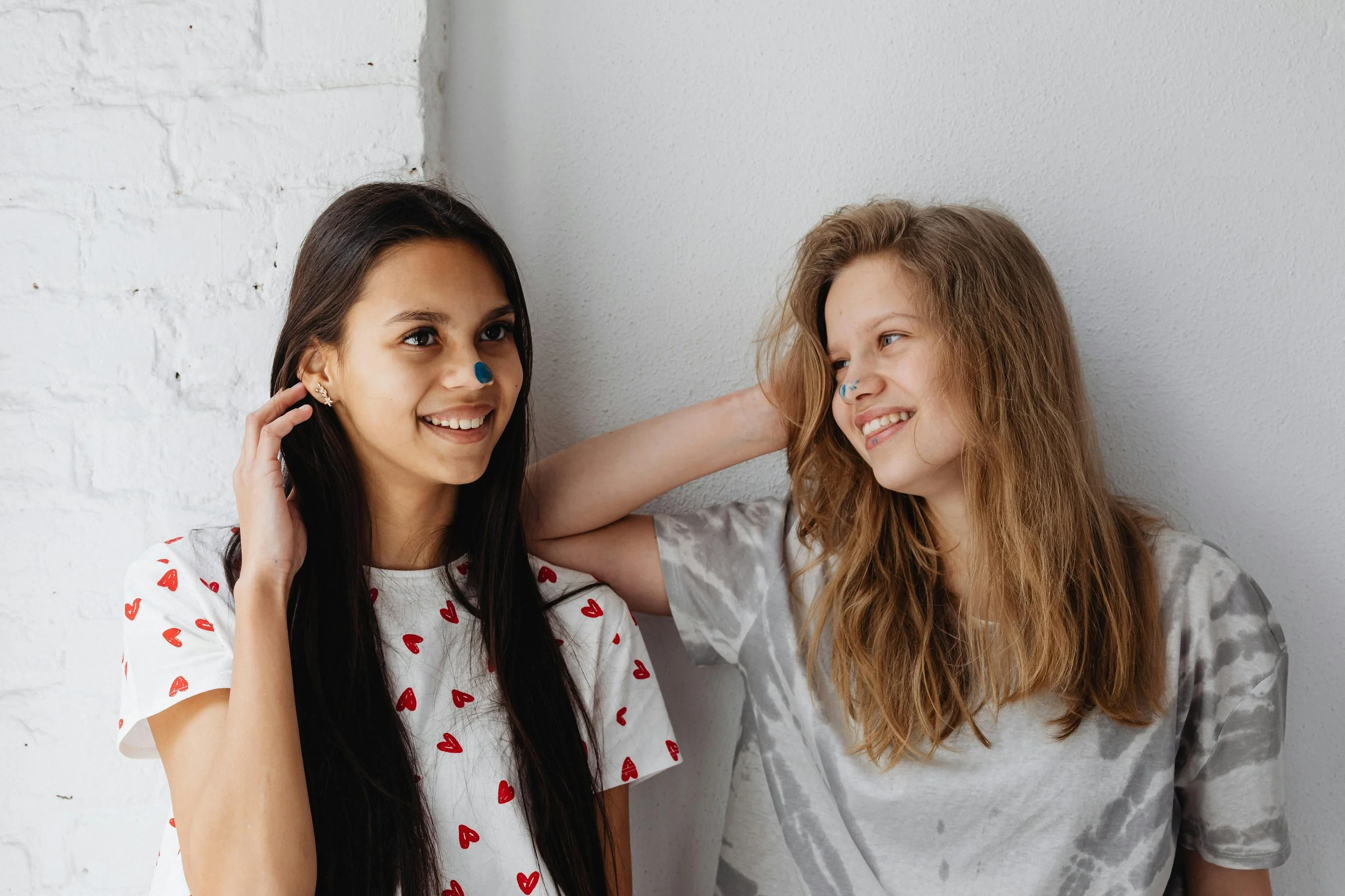 Two teenagers smiling, showing friendship and connection.