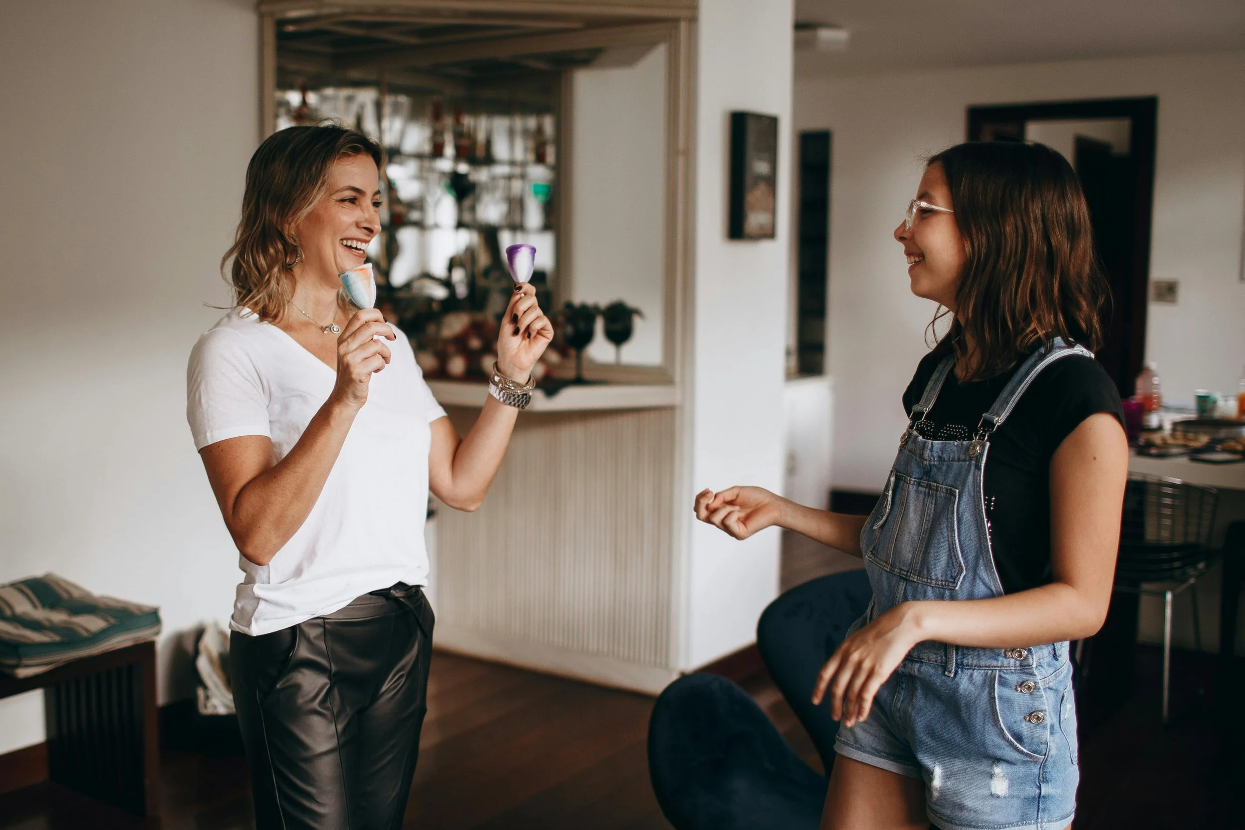 Mom and teen daughter smiling face to face, showing a positive and supportive relationship.