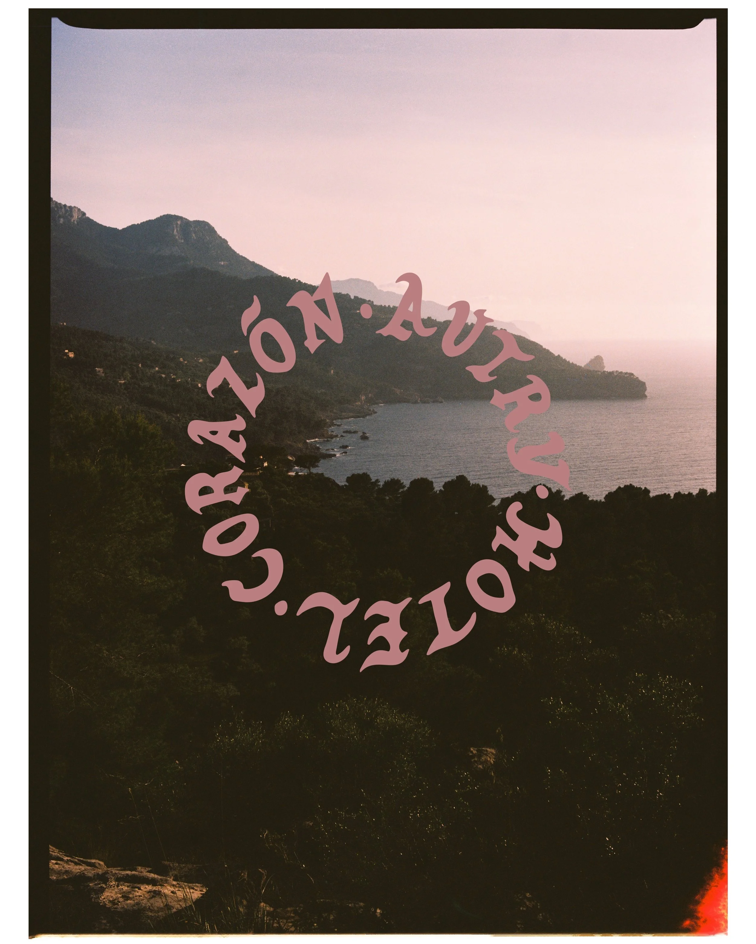 A landscape photograph of a coastal mountain scene at dusk with the sky in light pink and purple hues. There is a dark silhouette of trees and terrain along the shore in the foreground. Overlaid on the image are large, curved, pink text that reads "B