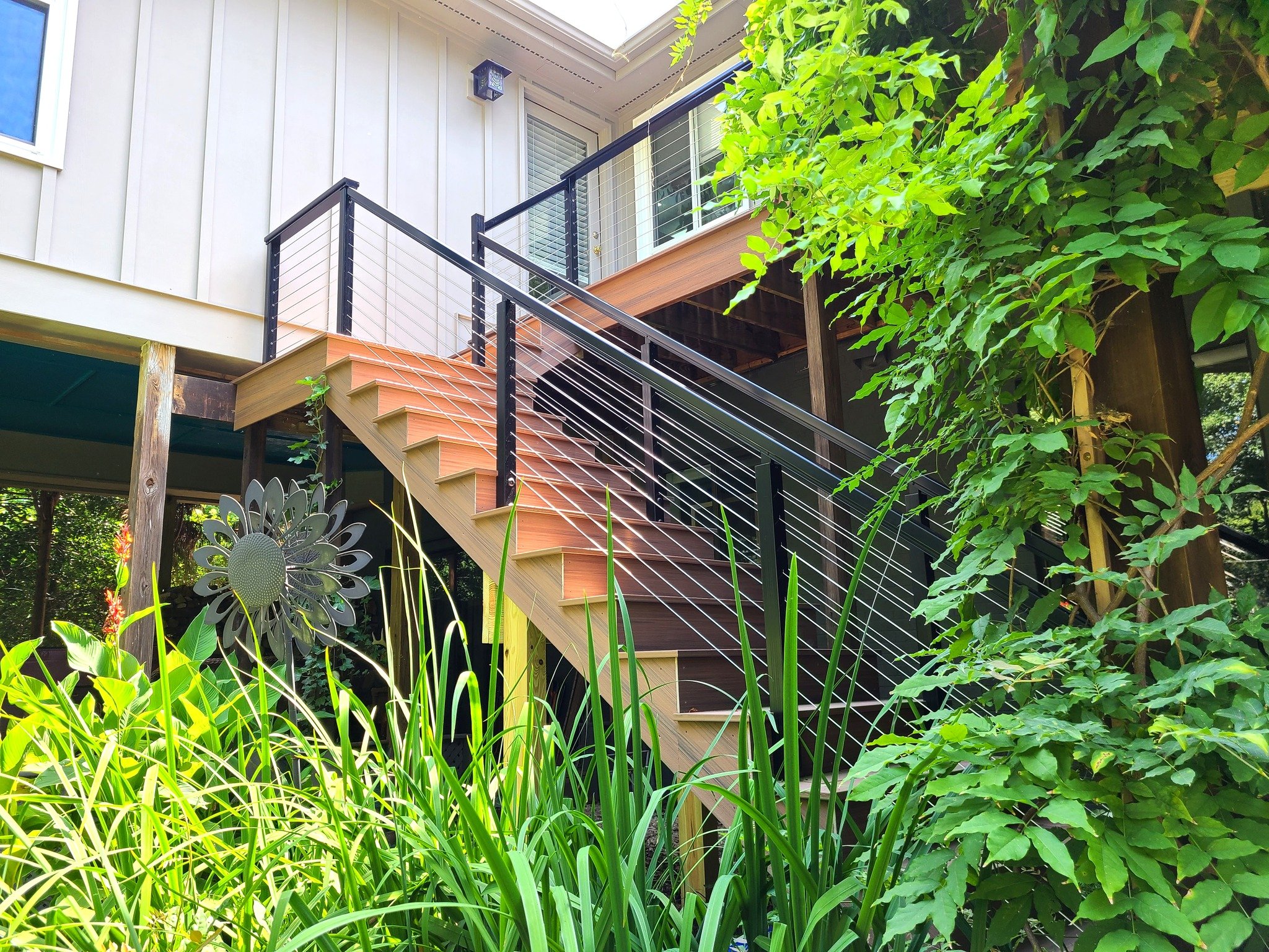 Reconstructed steps with new rail and matching fascia wrap on stringers - Decking: Deckorators Voyage Costa - Railing: RailFX cable