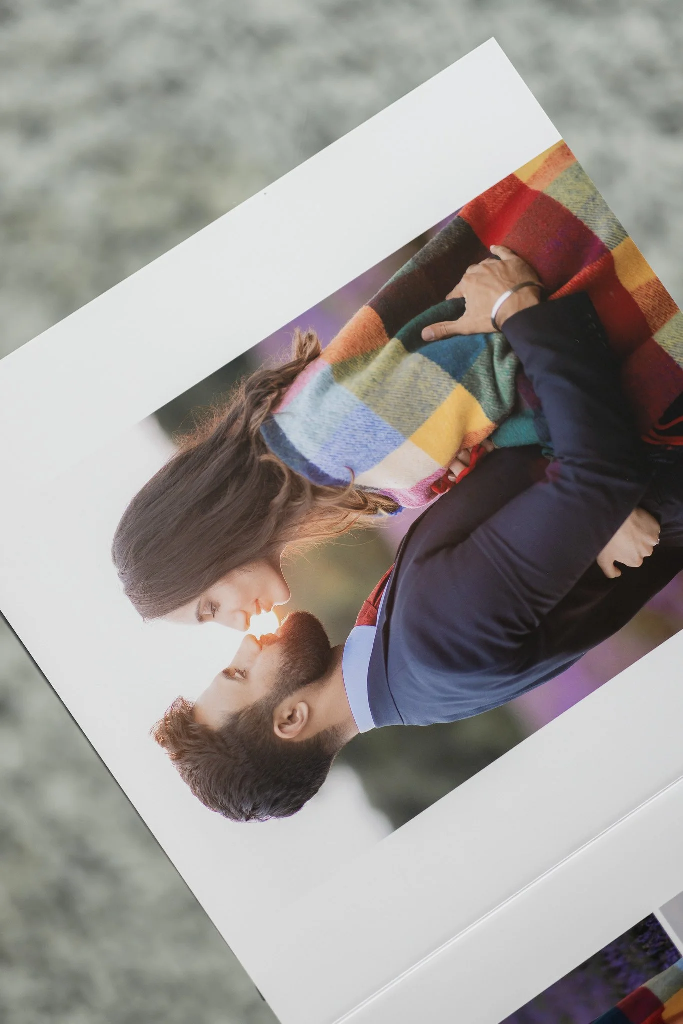 Close-up of a romantic couple embracing, woman wrapped in colorful scarf, photo printed on a page.