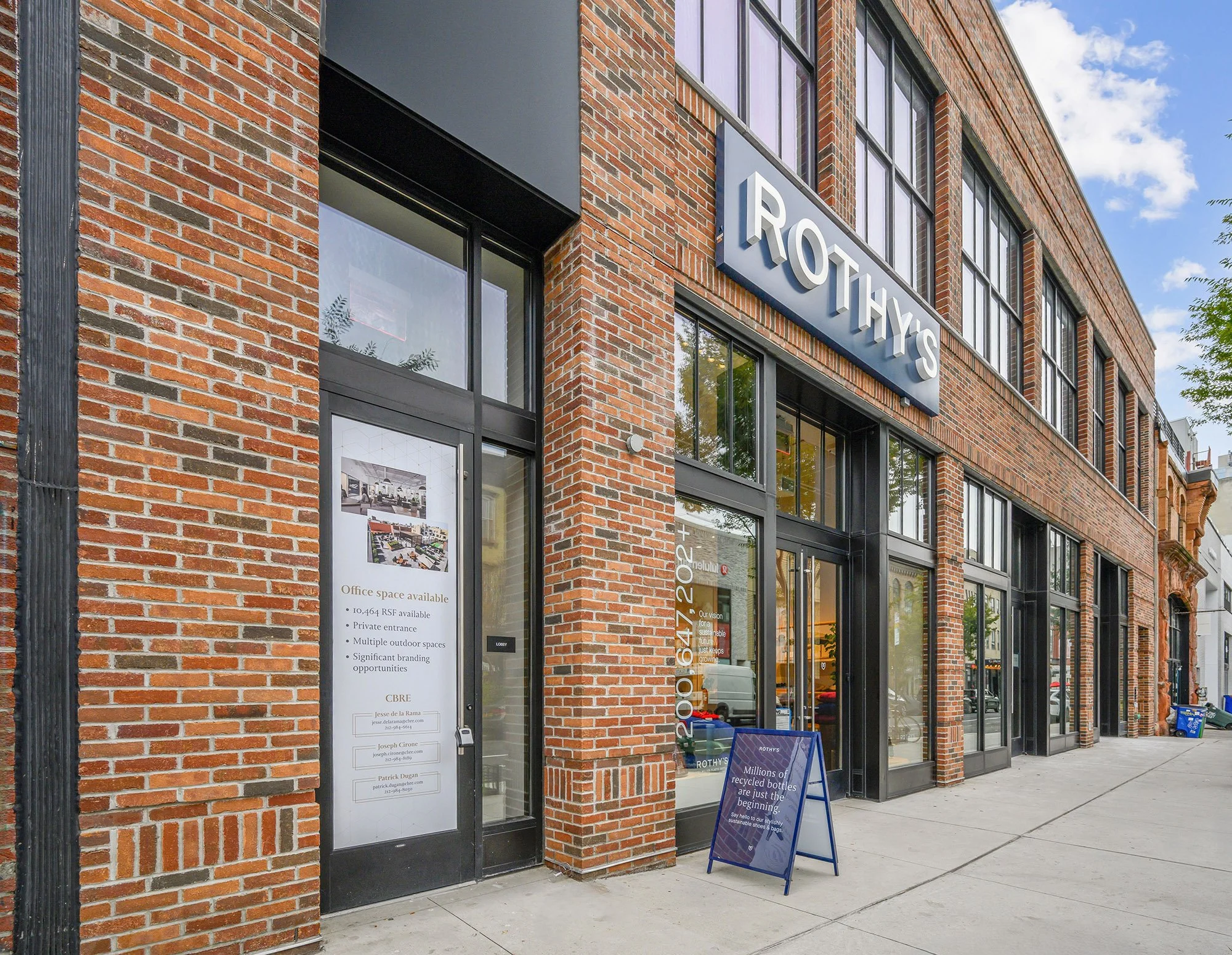 Exterior pale red brick new commercial retail  building with large glass windows for Rothy's shoe store. Williamsburg, Brooklyn