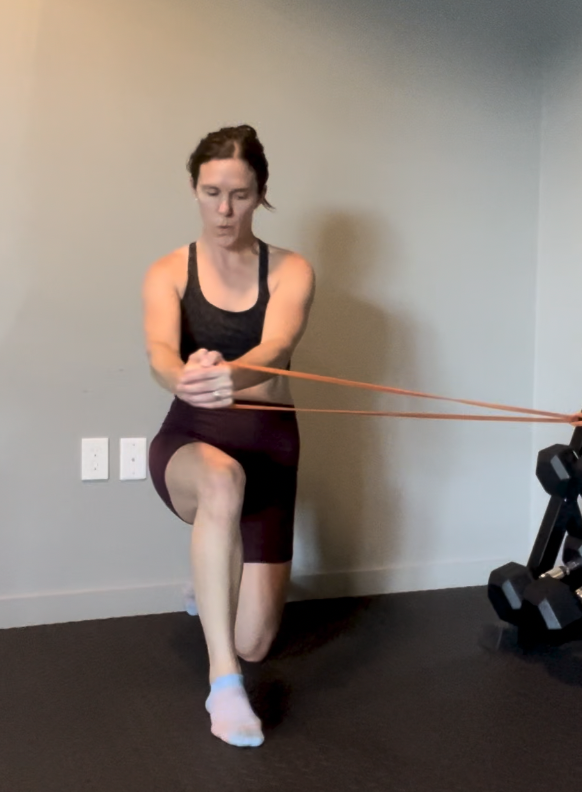 Postpartum woman exercising indoors  to rebuild core and pelvic floor strength and stability with resistance bands.