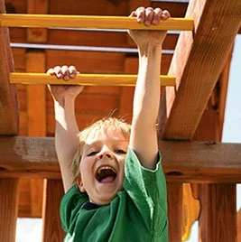 Child playing on monkey bars in a playground.