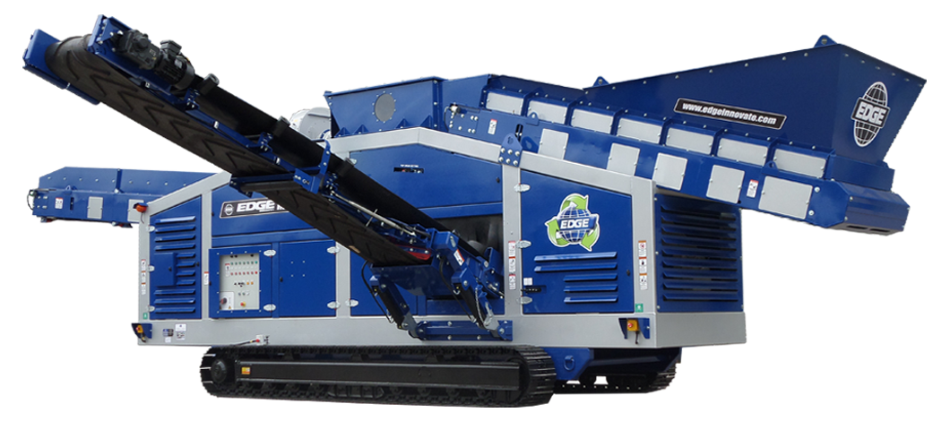 Blue industrial trash or recycling compactor with conveyor belt in a factory setting.