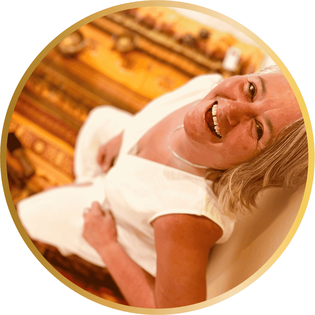 A photo of Shelley dressed in white, looking up at the camera with a great big smile on her face.