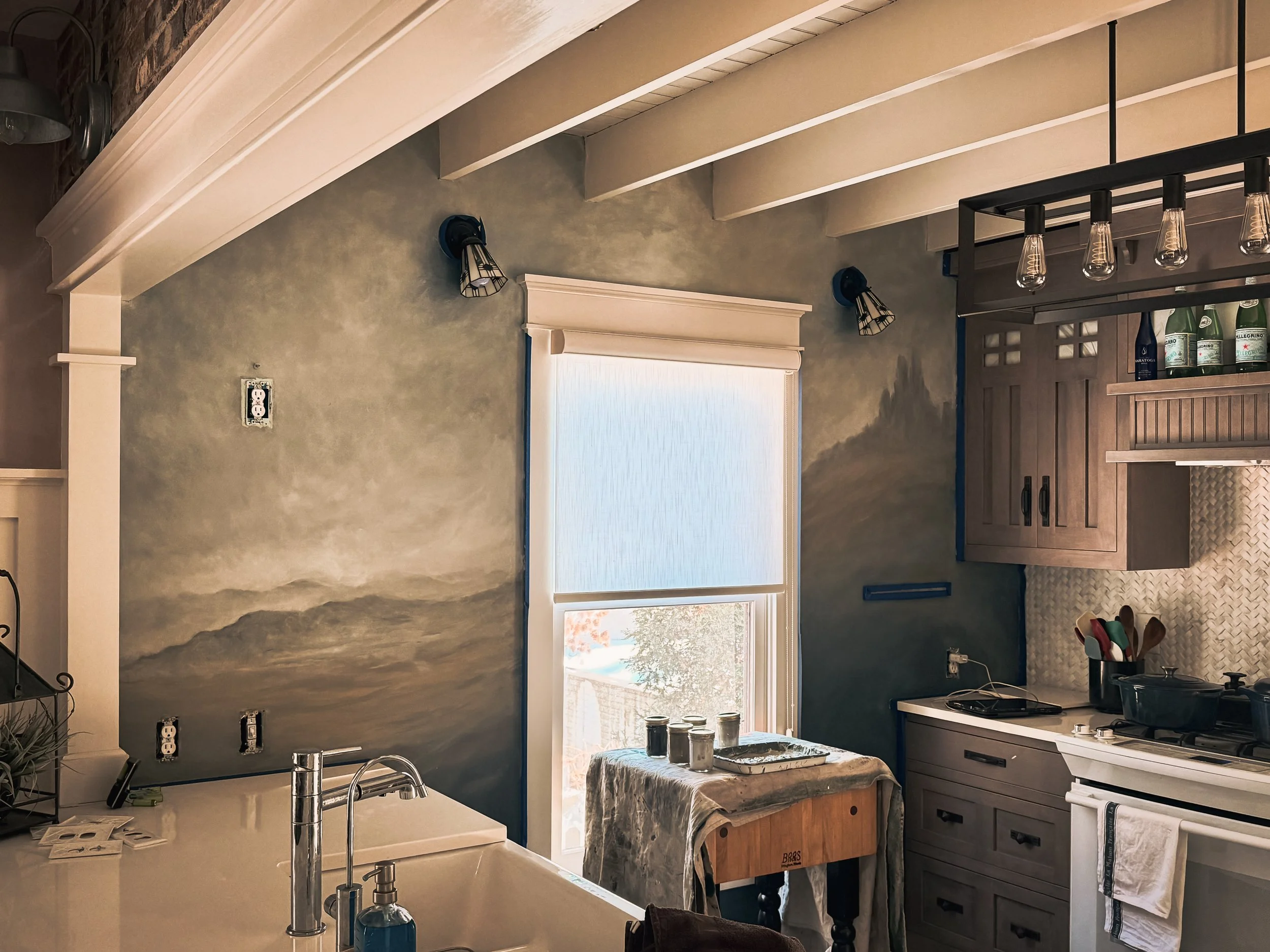 Atmospheric Landscape Kitchen Mural
Subtle monochromatic landscape mural integrated into a residential kitchen, with distant mountains and atmospheric clouds painted around the existing architecture.