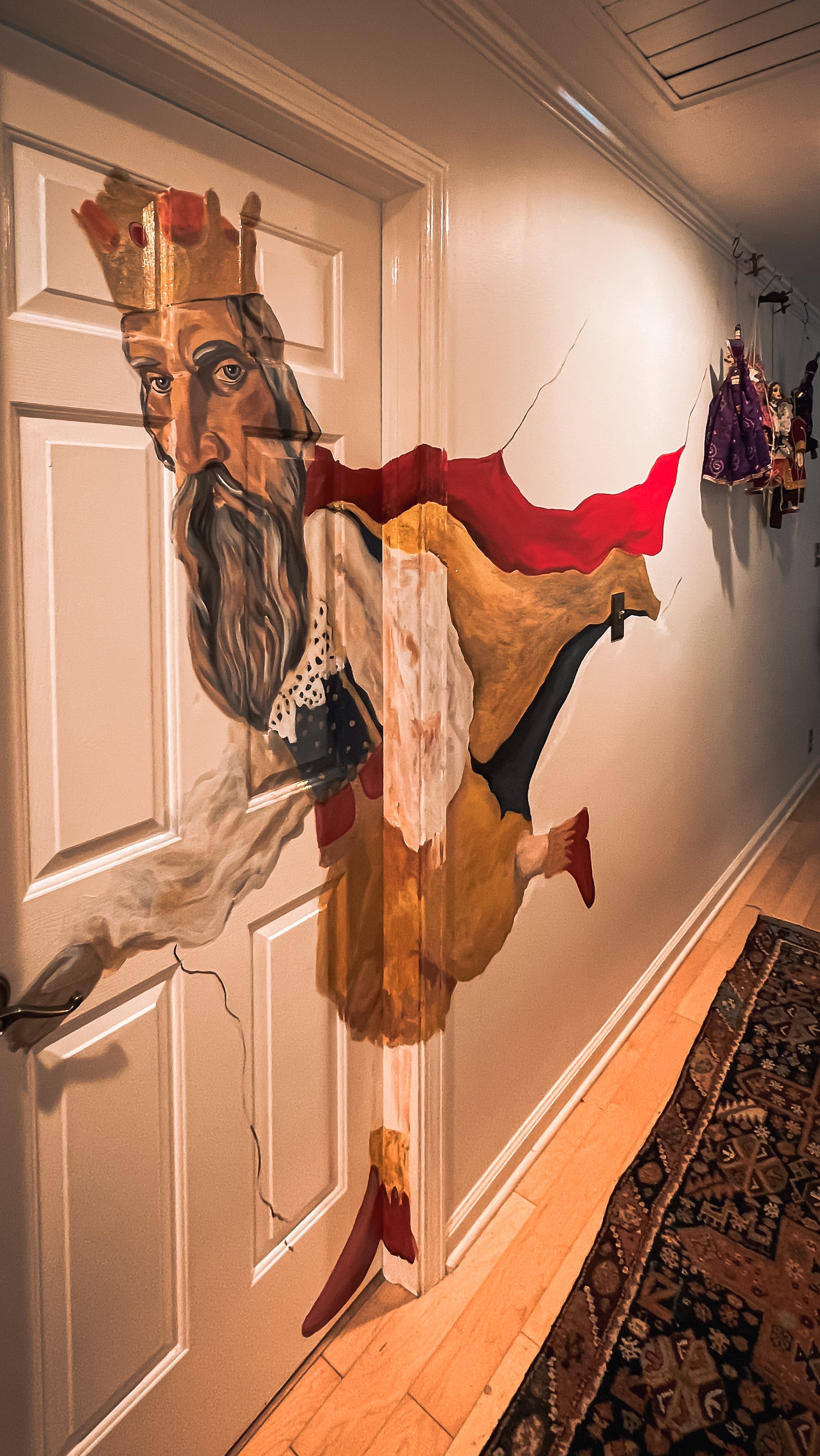 Trompe-l’oeil interior mural of a crowned king appearing to break through a doorway and surrounding wall.