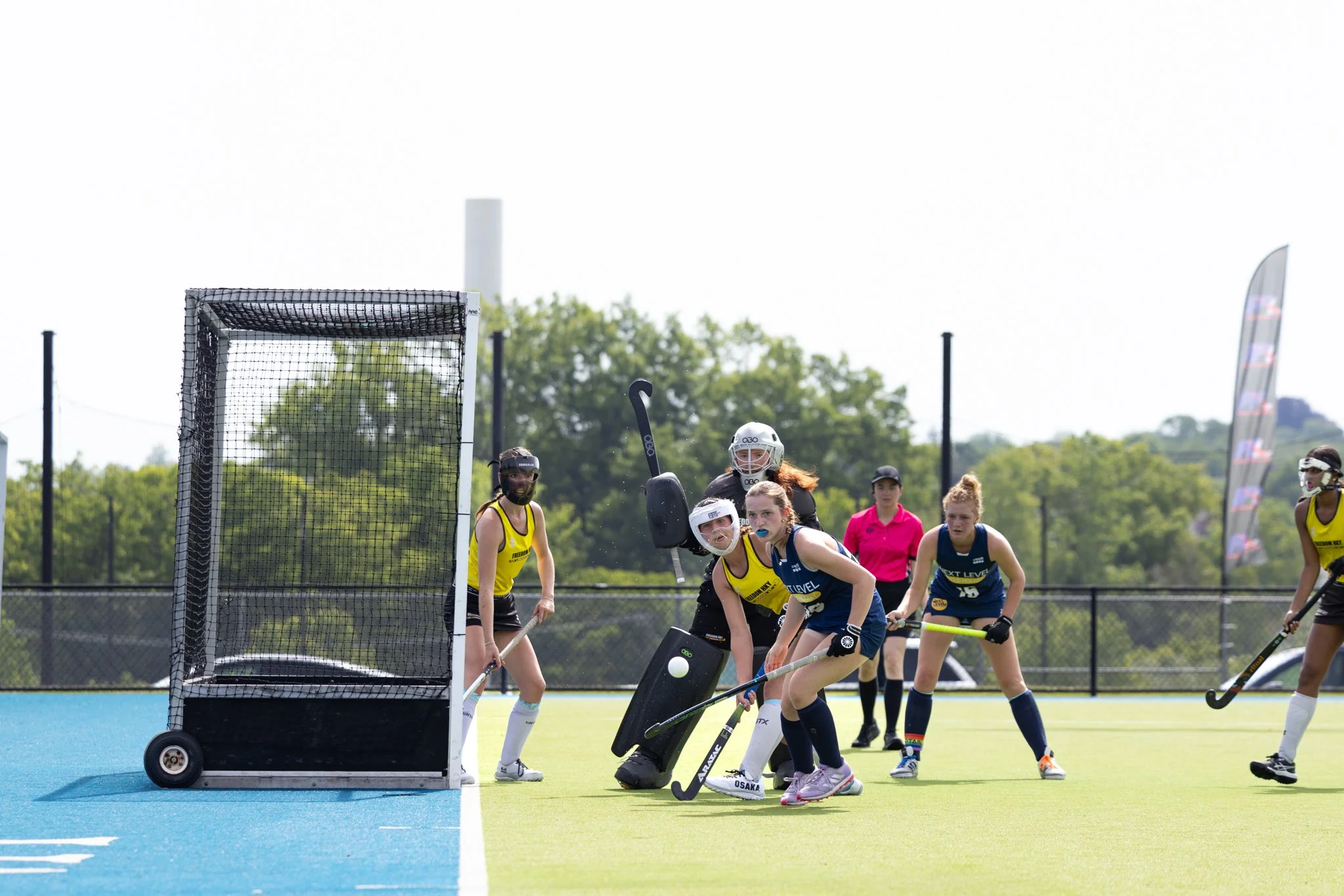 Field hockey players in the circle as the ball is in the air