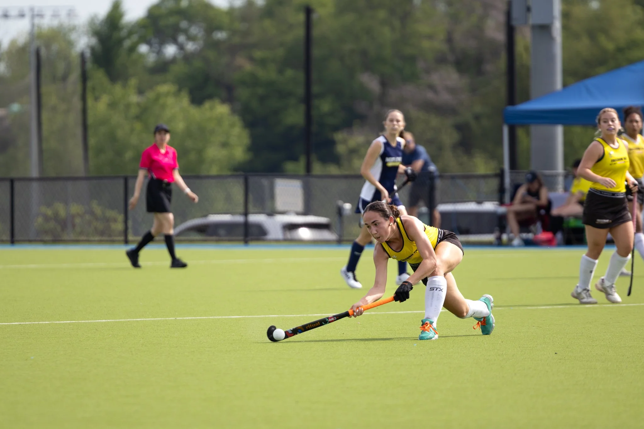 Field hockey player sweeping the ball at The Proving Grounds