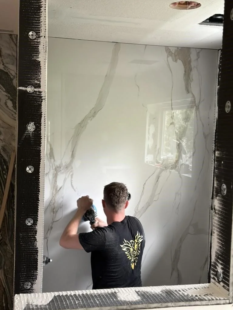 Adam uses a vibration tool to flatten thinset into place.