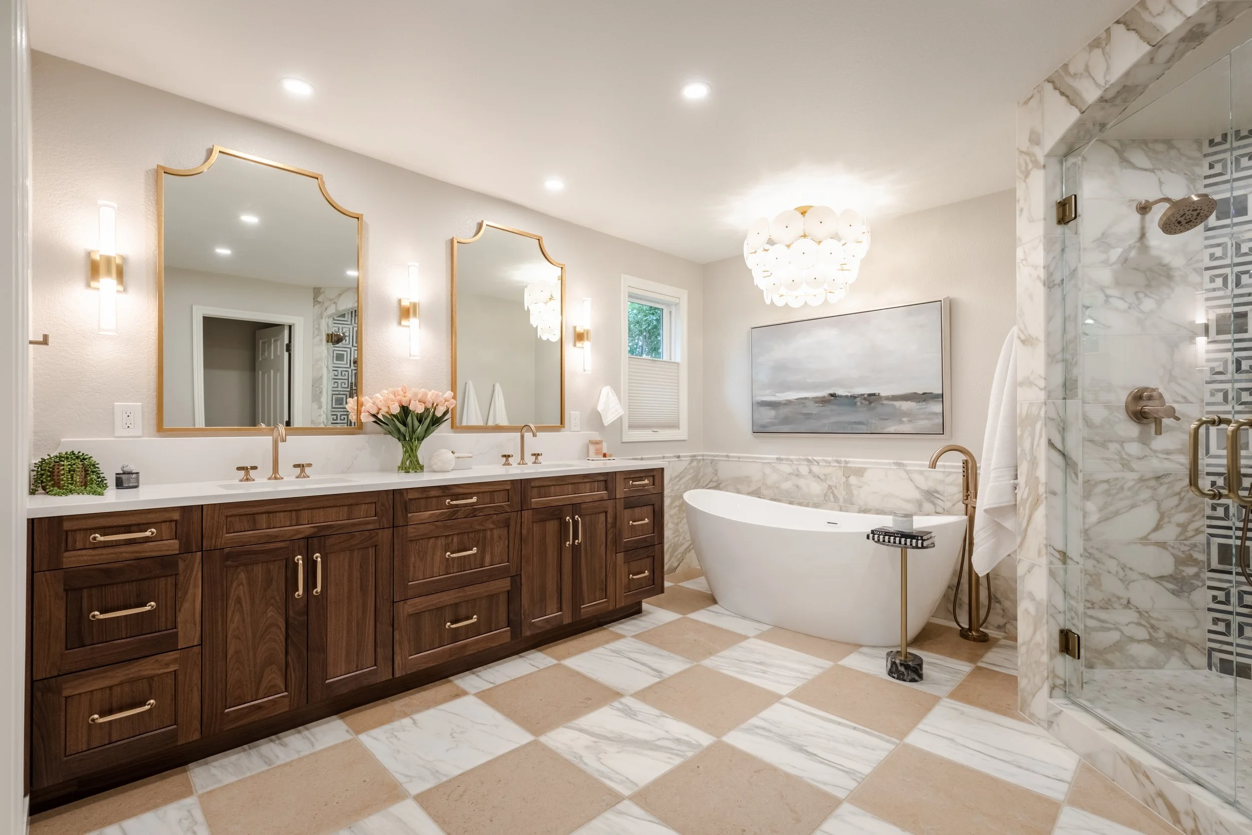 Modern bathroom with dual vanities, large mirrors, a freestanding bathtub, marble accents, and a walk-in shower.